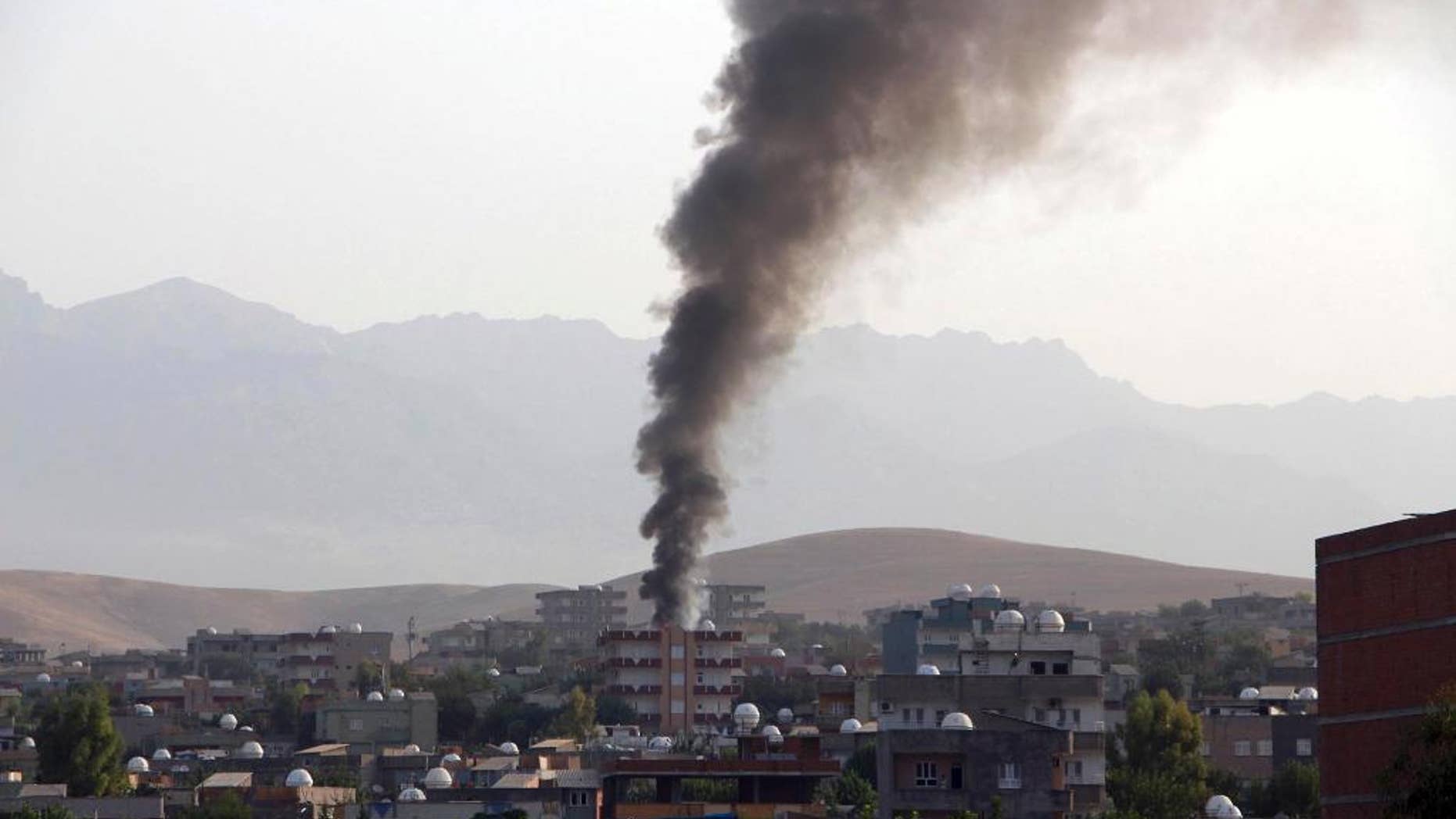 Smoke billows from a fire during firefight between the police and Kurdistan Workers' Party, or PKK militants in the town of Silopi, southeastern Turkey, Friday, July 7, 2015. Police clashed with supporters of a Kurdish rebel group in southeastern Turkey on Friday in a four-hour gunfight that killed three people, Turkey's state-run news agency reported. Violence has flared between the autonomy-seeking PKK, and Turkey's security forces in the past two weeks, wrecking an already fragile peace process between the government and the rebels. (Mehmet Selim Yalcin/Dogan News Agency via AP) TURKEY OUT
