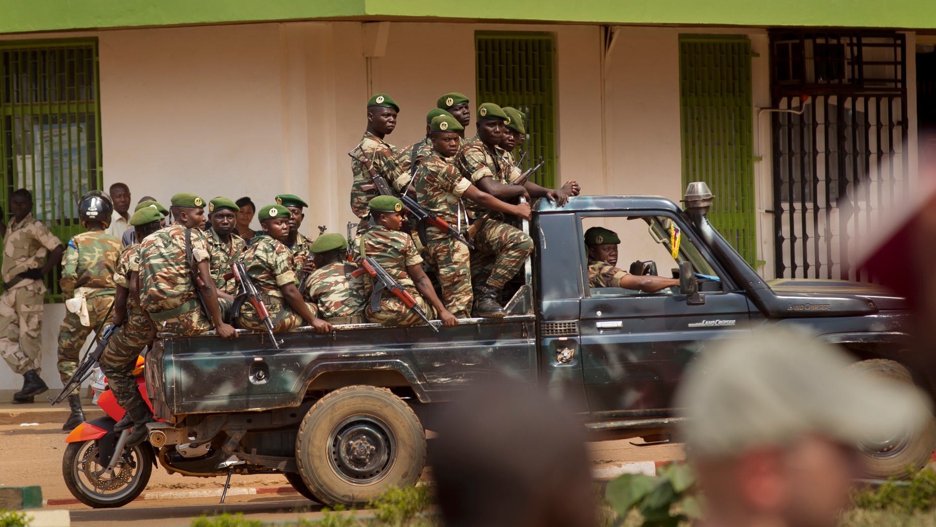 Government security forces in a pickup truck drive past a demonstration held by several hundred merchants calling for peace as negotiators prepare for talks with rebels from the north, in downtown Bangui, Central African Republic Saturday, Jan. 5, 2013. The U.N. Security Council urged rebels in the Central African Republic on Friday to halt their military offensive, withdraw from cities they have seized, and take part in negotiations to find a political solution to the impoverished country's longstanding problems. (AP Photo/Ben Curtis)