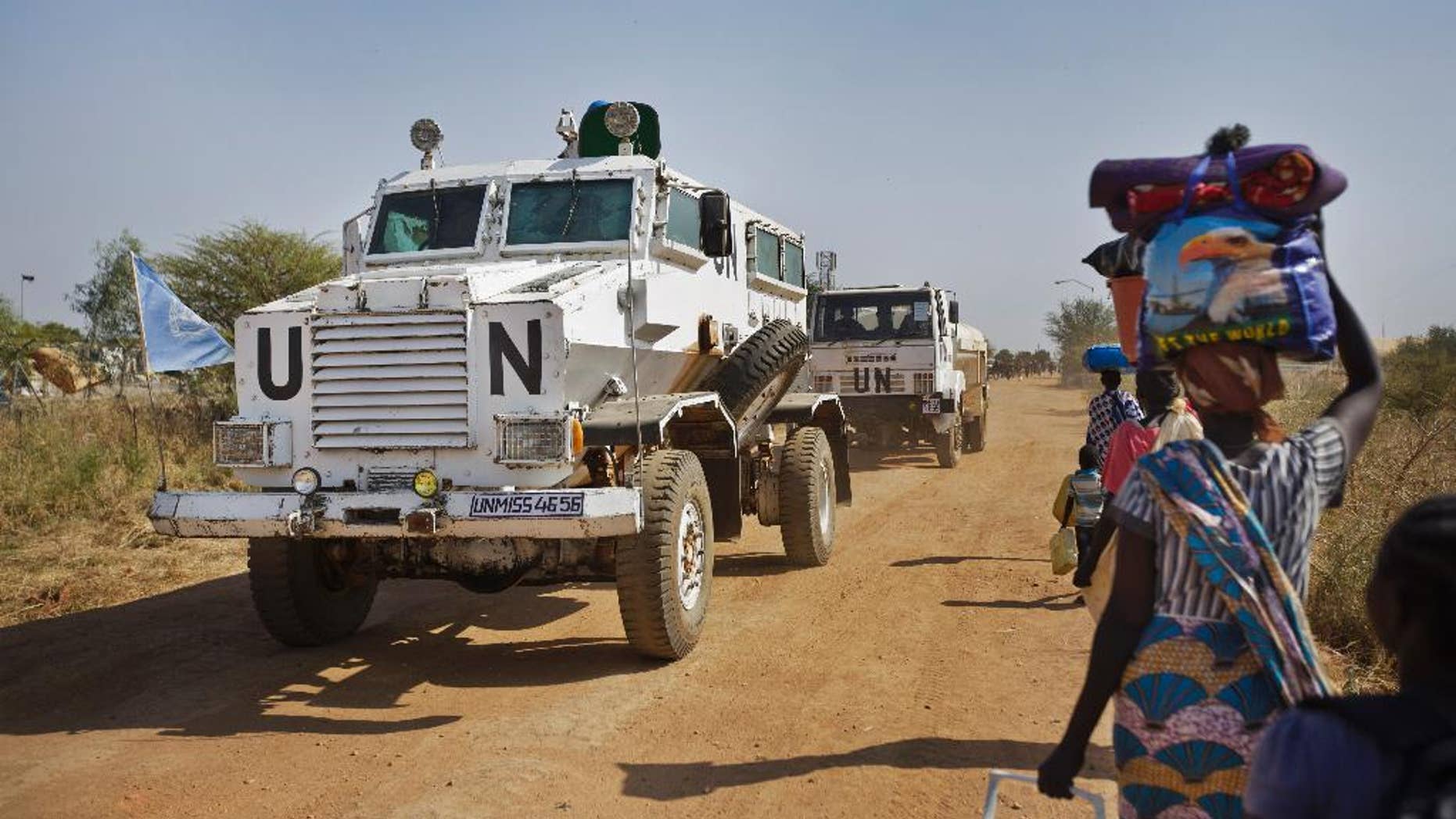 A United Nations armored vehicle passes people walking towards the U.N. camp in Malakal, South Sudan, in 2013.