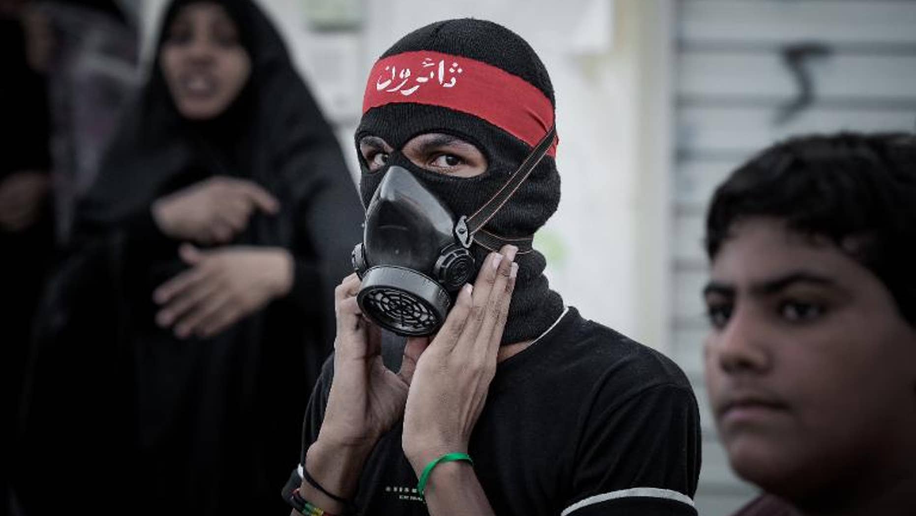 A Bahraini protester poses for a picture during clashes with riot police in the village of al-Maqsha, on September 21, 2013