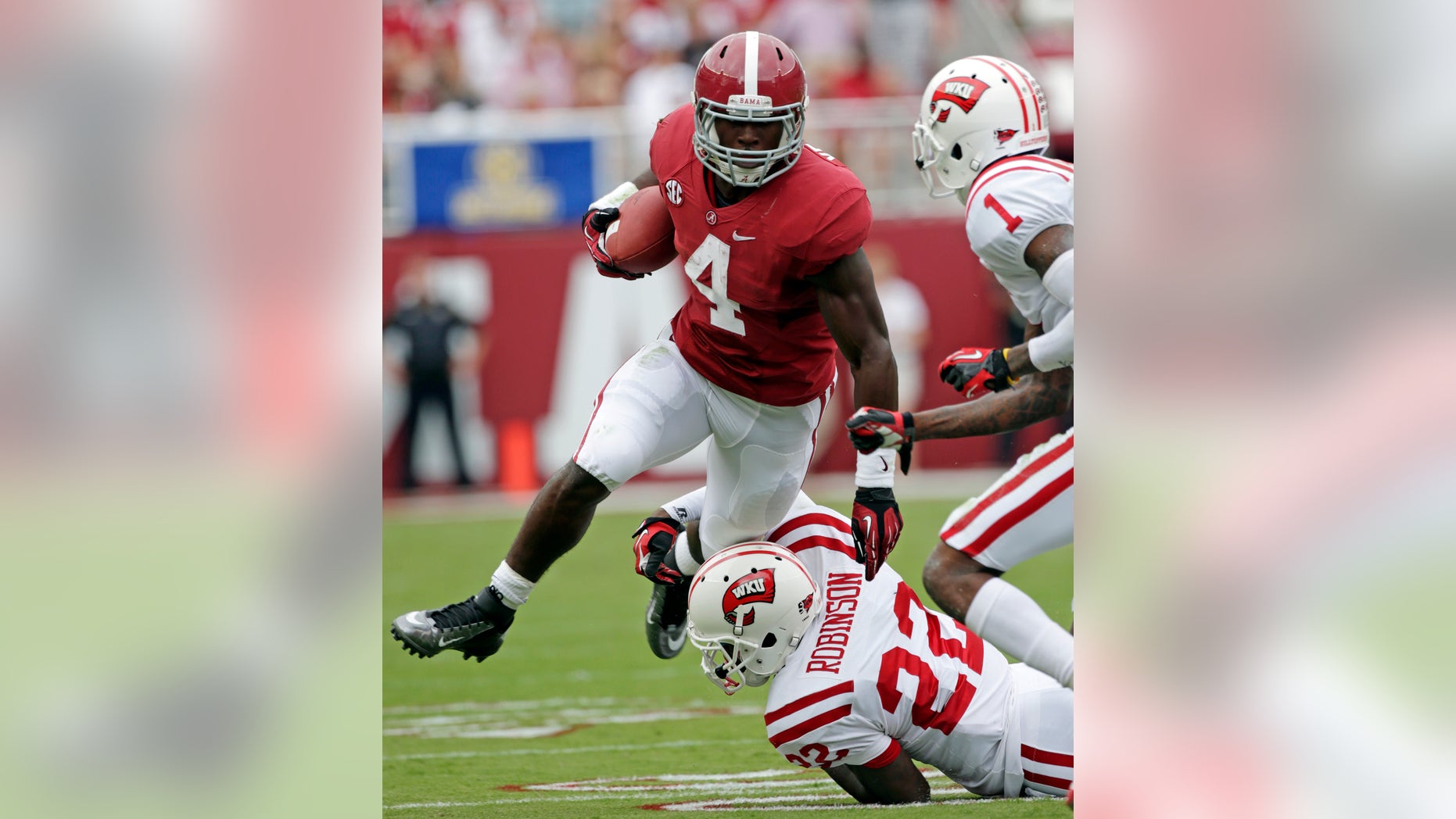FILE - In this Sept. 8, 2012, file photo, Alabama running back T.J. Yeldon (4) is taken down after a first down run by Western Kentucky defensive back Tyree Robinson (22) and defensive back Jonathan Dowling (1) during the first half of an NCAA college football game at Bryant Denny Stadium in Tuscaloosa, Ala. With the national championship on the line, two throwback offenses will slug it out. No. 1 Notre Dame and No. 2 Alabama rely heavily on the run, and that doesn't figure to change in the biggest game of the year. (AP Photo/Dave Martin, File)
