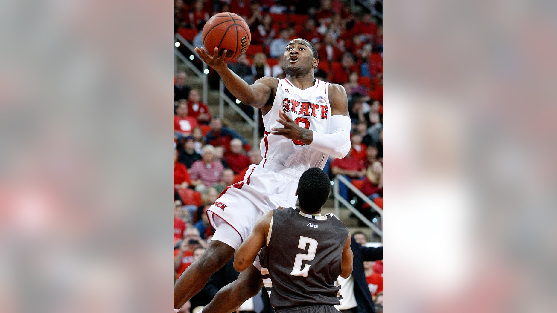 North Carolina State's Rodney Purvis (0) drives to the basket over St. Bonaventure's Eric Mosley (2) during the first half of an NCAA college basketball game in Raleigh, N.C., Saturday, Dec. 22, 2012. (AP Photo/Karl B DeBlaker)