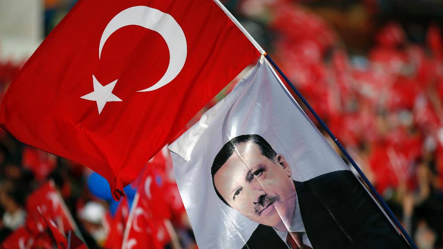 People wave national flags with an image of Turkey's President Recep Tayyip Erdogan during celebrations marking the 563rd anniversary of the Ottoman conquest of Constantinople, now Istanbul, in Istanbul, Turkey, Sunday, May 29, 2016. (AP Photo/Emrah Gurel)