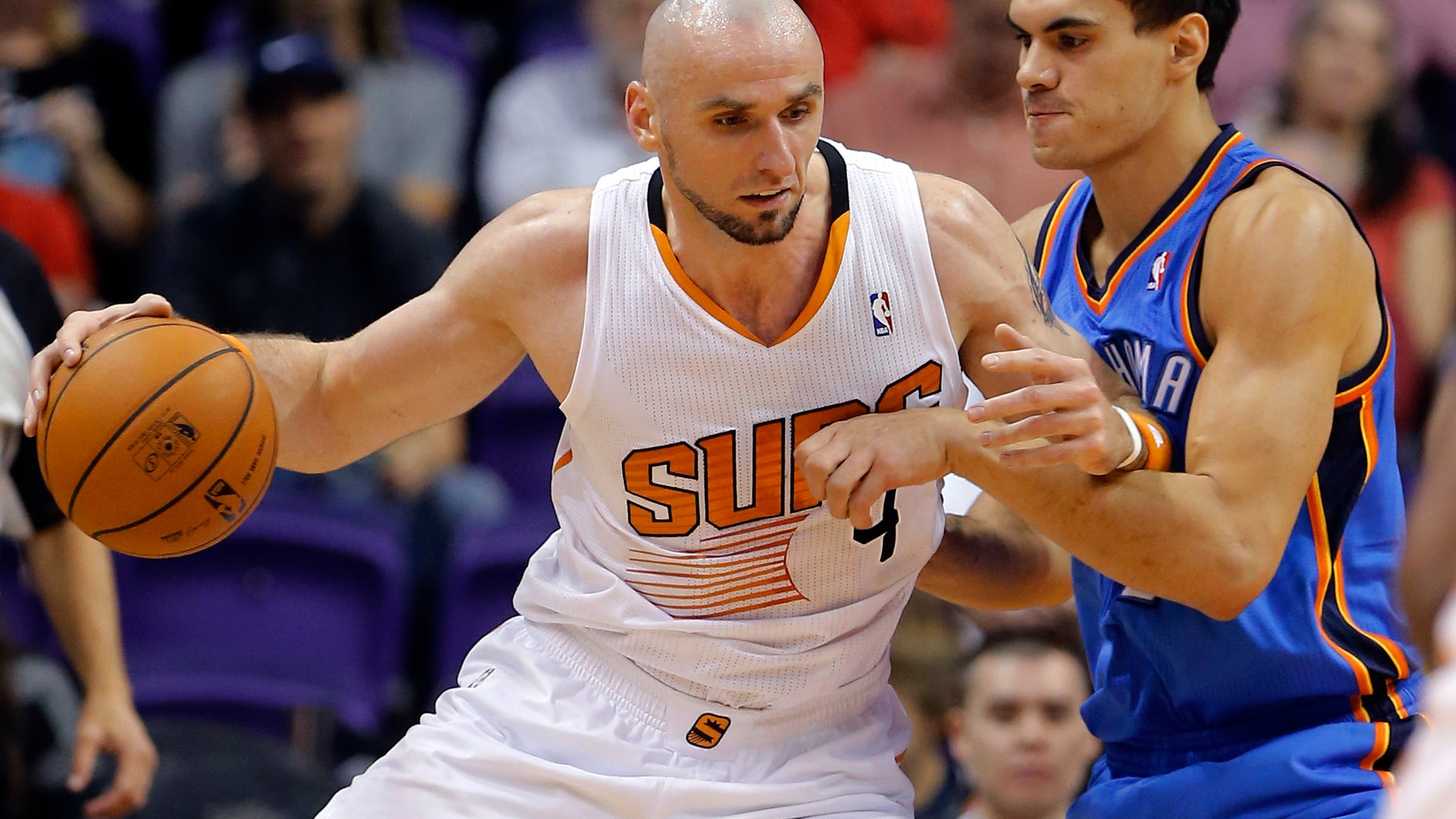 Phoenix Suns center Marcin Gortat, of Poland, backs down Oklahoma Thunder center Steven Adams, right, during the first half of an NBA preseason basketball game, Tuesday, Oct. 22, 2013, in Phoenix. (AP Photo/Matt York)