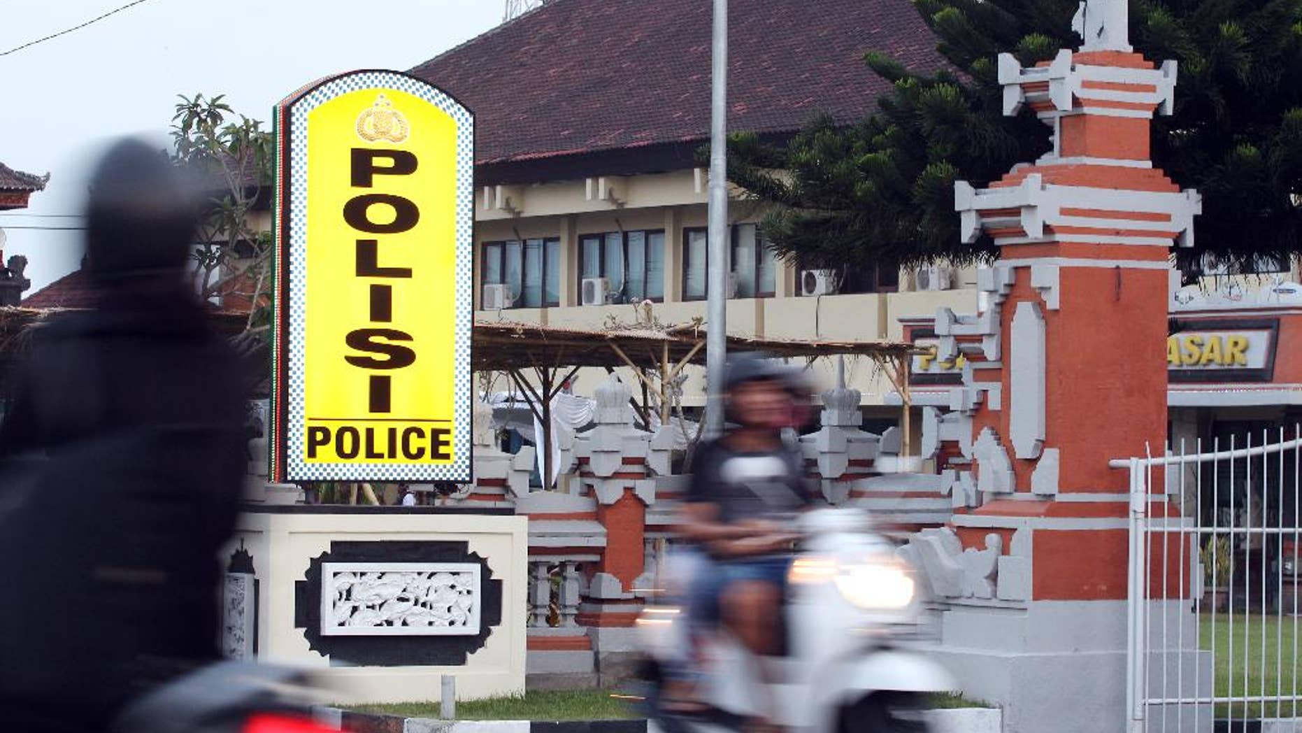 Motorcyclists pass by Denpasar's police station where Rajendra Sadashiv Nikalje is detained, in Bali, Indonesia, Monday, Oct. 26, 2015. Nikalje, known in India as “Chotta Rajan,” an alleged mafia boss in his homeland was on the Interpol’s most wanted list for two decades, said Bali police spokesman Heri Wiyanto. Wiyanto said Nikalje was arrested Sunday after arriving at Bali’s airport from Sydney, based on a red notice from Interpol and following a tip from Australian authorities in Canberra. (AP Photo/Firdia Lisnawati)