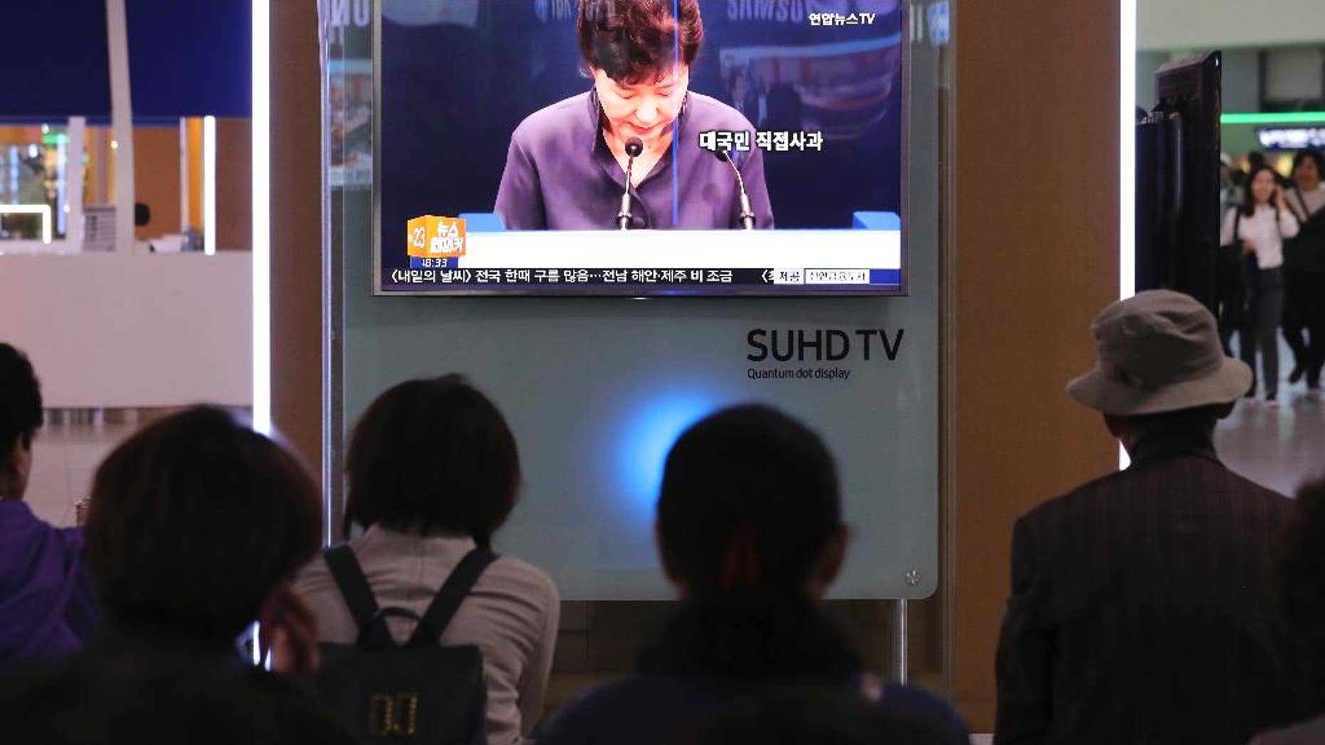 In this Oct. 25, 2016 photo, people watch a TV screen showing the news program about South Korean President Park Geun-hye's apology, at Seoul Railway Station in Seoul, South Korea. To outsiders, the frenzy that has erupted here may not seem to match this week’s acknowledgment by South Korean President Park that she got help, including the editing of some of her speeches, from a mysterious woman outside of the government. But Park’s surprise televised address has created one of the biggest challenges of her four years in power - and touched a deep chord in this divided nation. (AP Photo/Lee Jin-man)