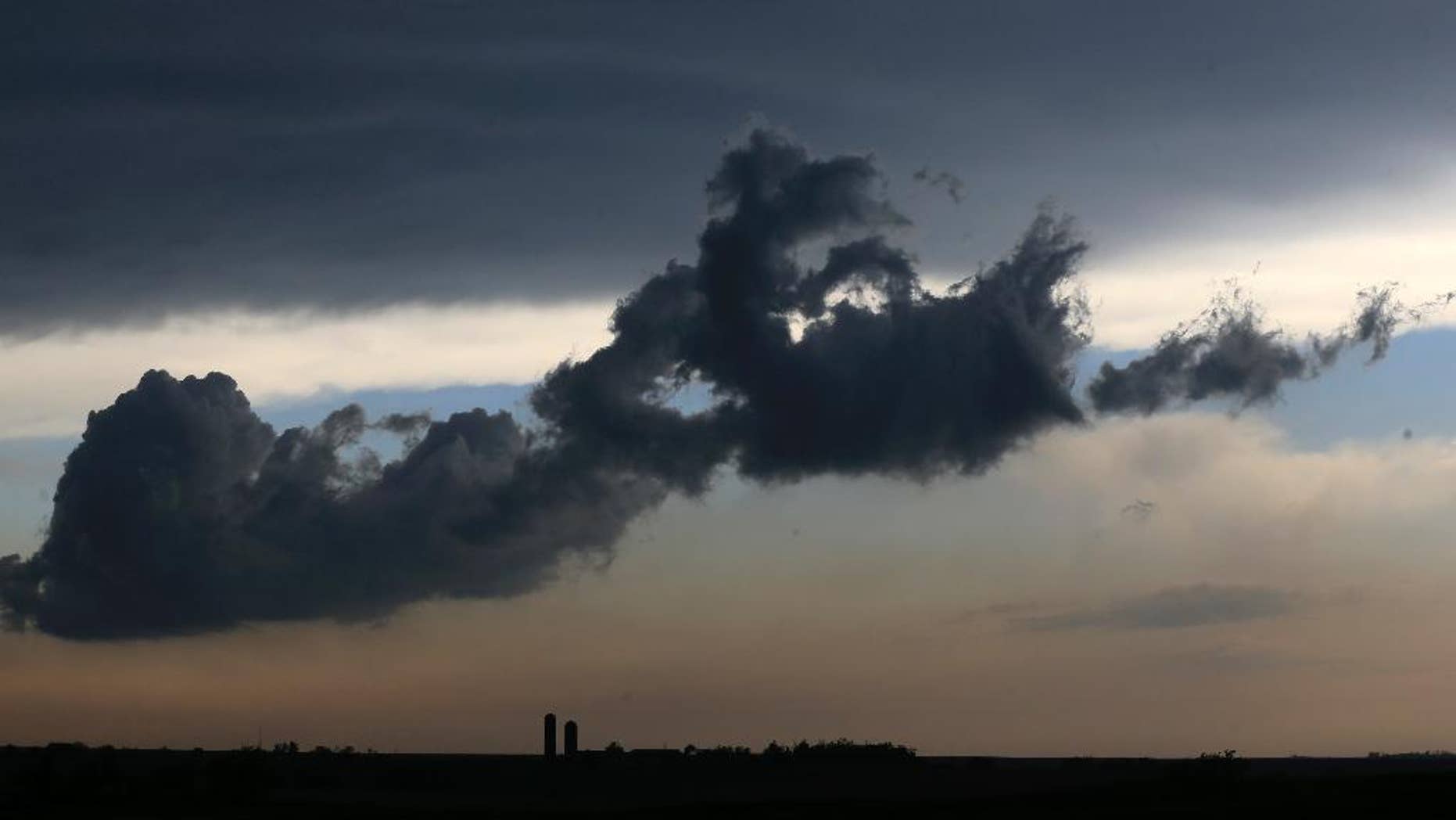 A low cloud moves over a farm near Gypsum, Kan., Tuesday, April 26, 2016. Thunderstorms bearing hail as big as grapefruit and winds approaching hurricane strength lashed portions of the Great Plains on Tuesday. The area is expecting severe weather. (AP Photo/Orlin Wagner)