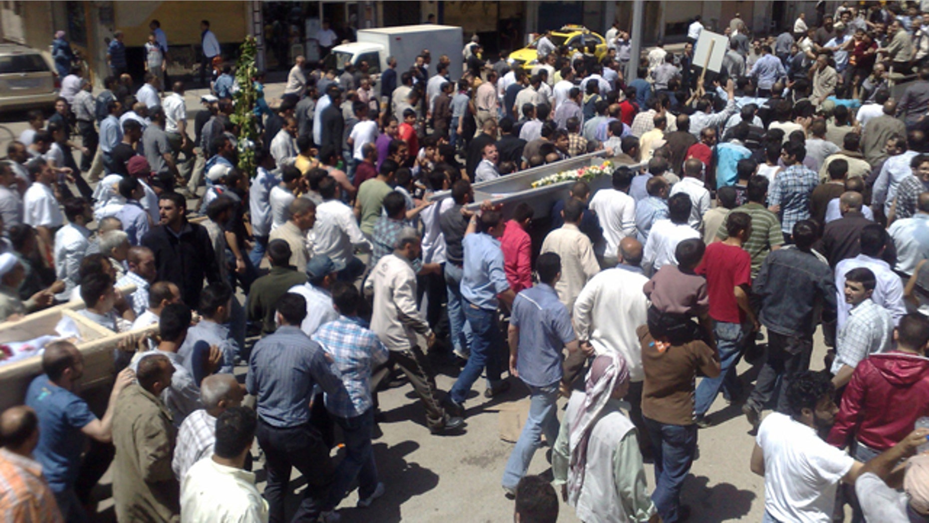 May 21: In this citizen journalism image made on a mobile phone and acquired by the AP, Syrian anti-government supporters carry the coffins of people whom they say were killed in the government crackdown, in the central city of Homs, Syria.