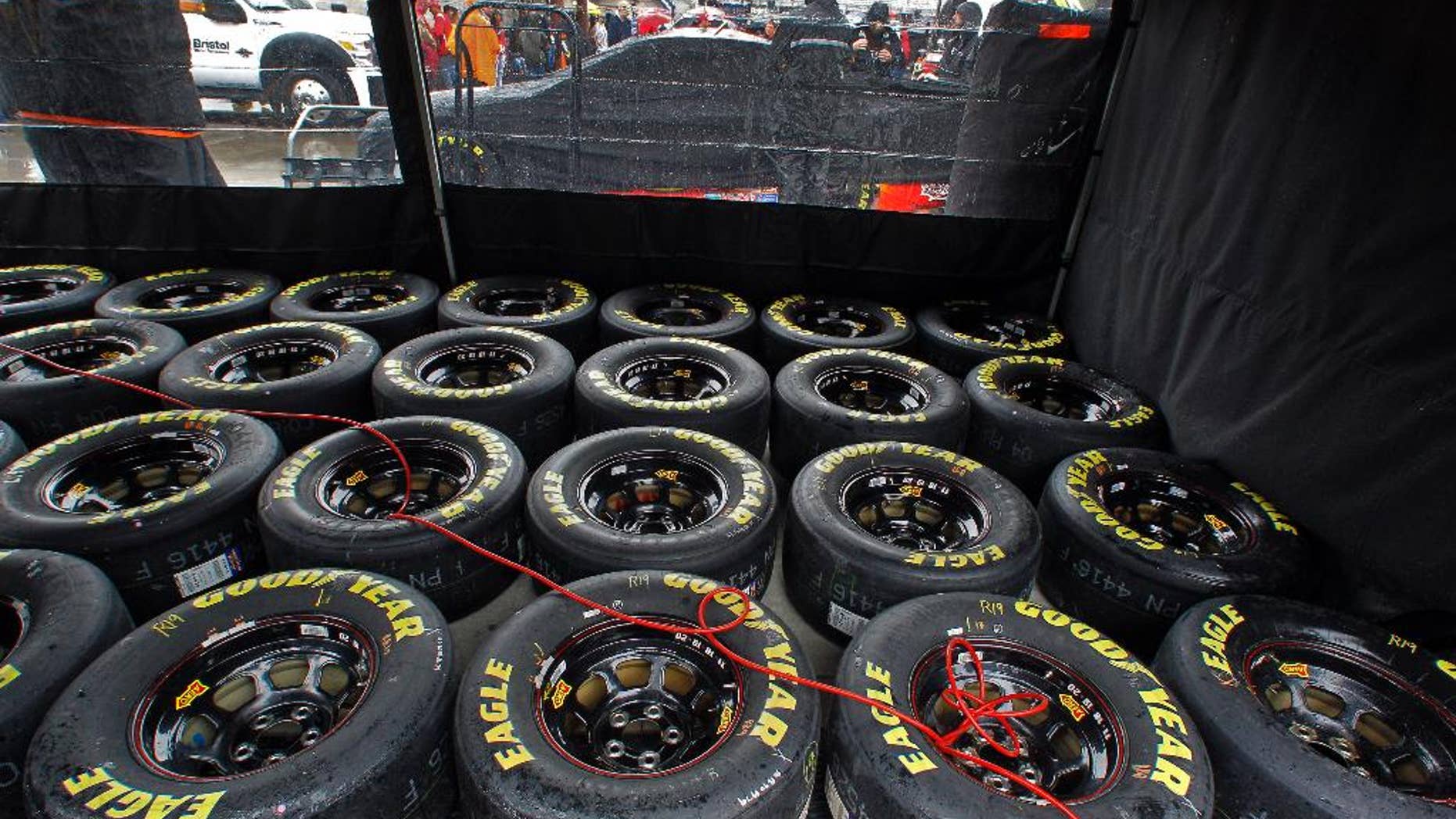 Tires sit under a tent as rain falls before a NASCAR Sprint Cup Series auto race at Bristol Motor Speedway on Sunday, April 19, 2015, in Bristol, Tenn. (AP Photo/Wade Payne)