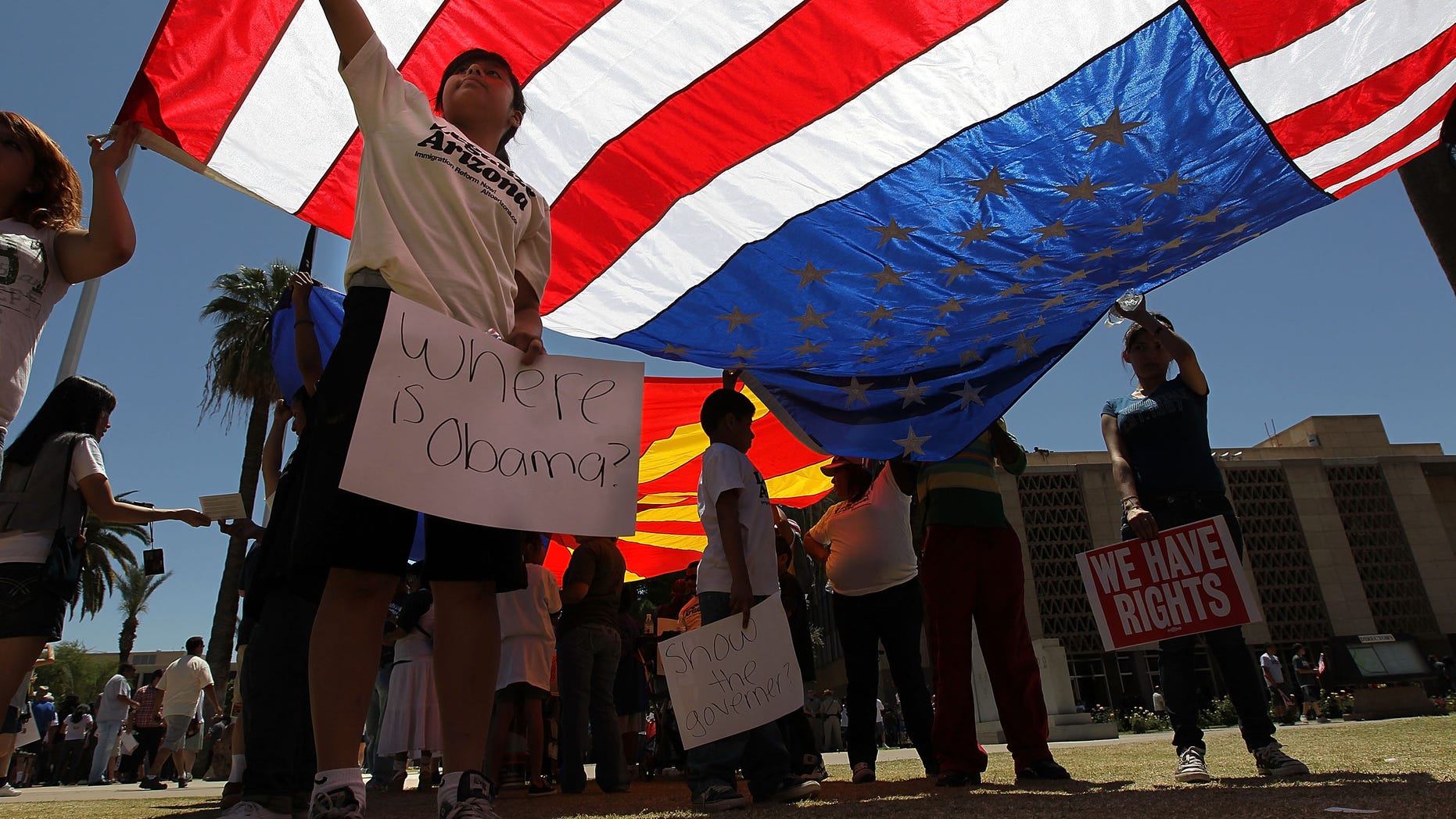PHOENIX - APRIL 25: Opponents of Arizona's new immigration enforcement law protest outside the state capitol building on April 25, 2010 in Phoenix, Arizona. More than 1,000 gathered to protest the passage of Arizona's tough new law which was signed by the state's Republican governor Jan Brewer two days before. Critics of the law say that it will encourage racial profiling by law enforcement and endanger civil rights in the state. (Photo by John Moore/Getty Images)