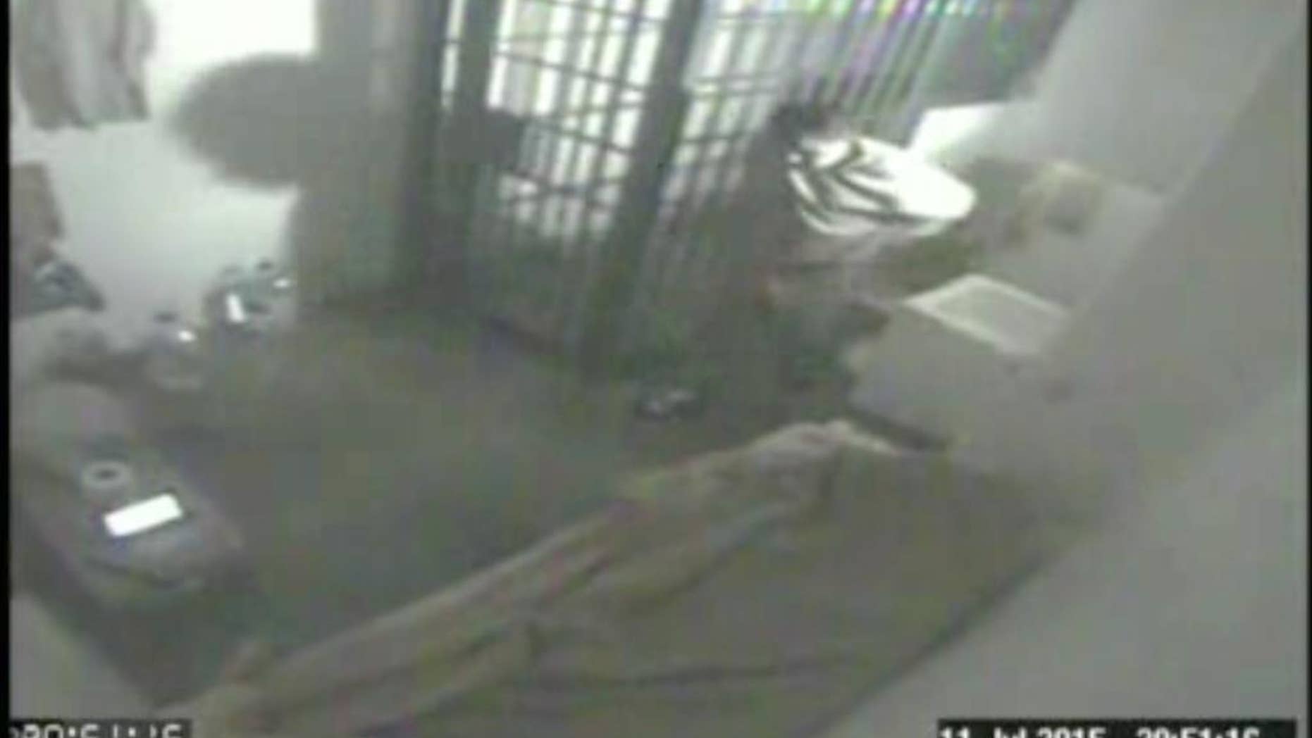 FILE - In this file screen grab of video from a security camera, dated July 11, 2015 and released by Mexico's National Security Commission, shows the man Mexican authorities say is Joaquin "El Chapo" Guzman, pacing inside his cell at the Altiplano maximum security prison, shortly before escaping through a tunnel below the shower area, top right, in Almoloya, Mexico. A new closed circuit prison video broadcast Wednesday, Oct. 14, 2015, by the Mexican television chain Televisa, reveals hammering sounds several minutes before the country's most notorious drug lord escaped from his cell through a tunnel. (Mexico's National Security Commission via AP, File)