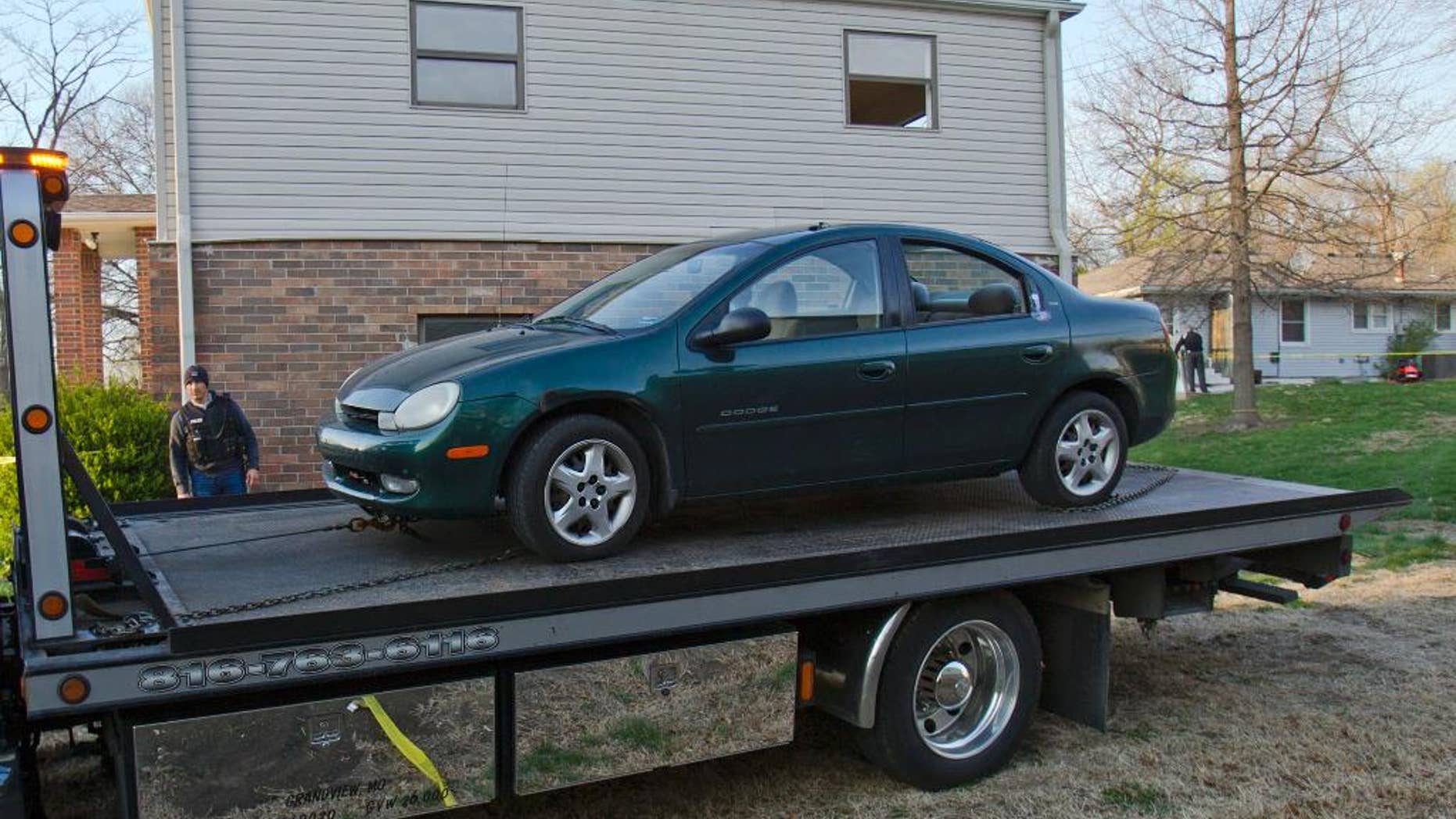A car is removed by Kansas City police from the house (far right) of a Grandview man suspected in a series of shootings that have occurred on area roadways since early March, according to Police Chief Darryl Forté. The suspect was arrested late Thursday, April 17, 2014, in the 6000 block of East 136th Street of Grandview, Mo., which is just east of Interstate 49 and south of the Three Trails Crossing area where seven shootings happened. (AP Photo/The Kansas City Star,Allison Long)