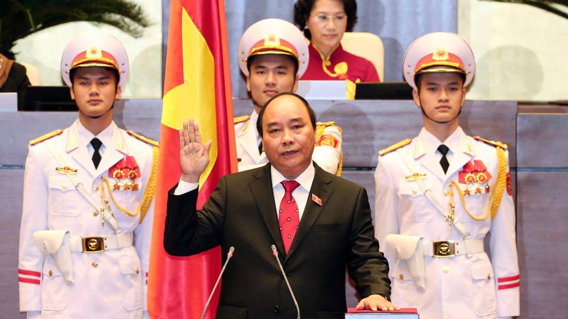 Nguyen Xuan Phuc, center, takes oath after being elected as prime minister in Hanoi, Vietnam Thursday April, 7, 2016. Vietnam’s National Assembly on Thursday elected Phuc as prime minister, and he takes office at a time of soaring public debt, a serious budget deficit and China’s growing assertiveness in the South China Sea. (Thong Nhat/Vietnam News Agency via AP)