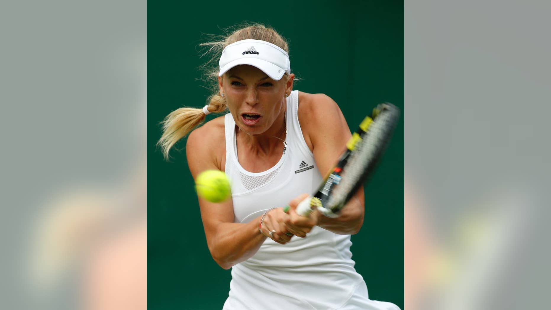 Caroline Wozniacki of Denmark plays a return to Shahar Peer of Israel during their first round match at the All England Lawn Tennis Championships in Wimbledon, London, Monday, June 23, 2014. (AP Photo/Alastair Grant)