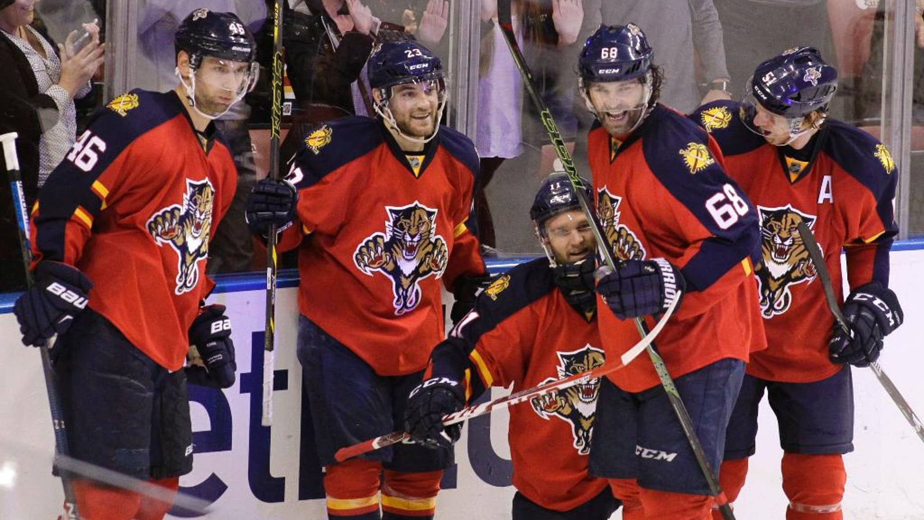 Florida Panthers’ Jonathan Huberdeau, third from left, celebrates with teammates Jakub Kindl (46), of the Czech Republic, Rocco Grimaldi, second from left, Jaromir Jagr (68), of the Czech Republic, and Brian Campbell, right, after scoring a goal during the third period of an NHL hockey game against the New Jersey Devils, Thursday, March 31, 2016, in Sunrise, Fla. The Panthers won 3-2. (AP Photo/Luis M. Alvarez)