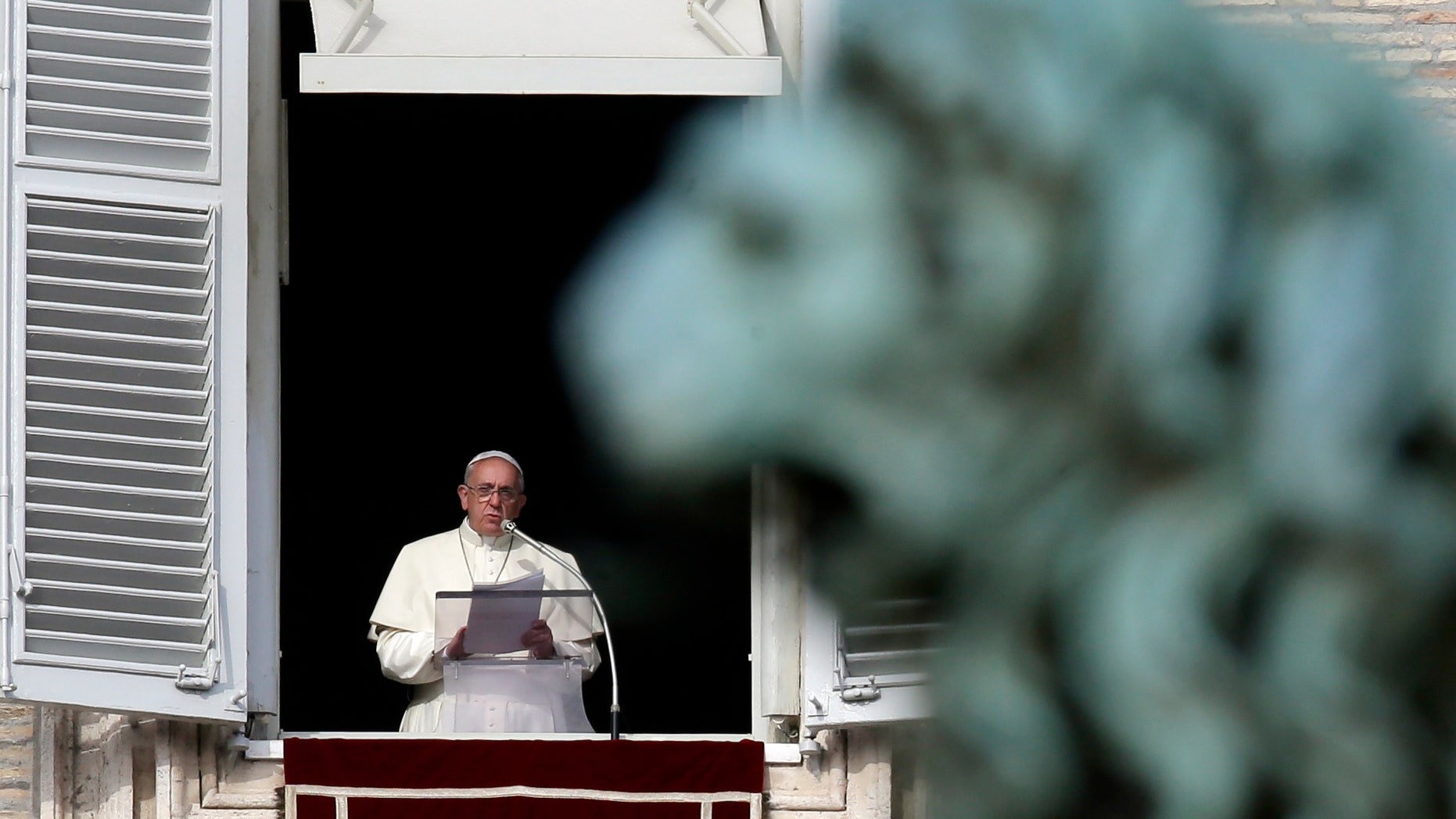 Pope Francis reads the list of 19 new Cardinals during the Angelus prayer in St. Peter's Square, at the Vatican, Sunday, Jan. 12, 2014. The pontiff has named his first batch of cardinals, choosing 19 men from Asia, Africa, North and South America and elsewhere, including Haiti and Burkina Faso, to reflect his attention to the poor. Francis made the announcement Sunday as he spoke from his studio window to a crowd in St. Peter's Square. (AP Photo/Gregorio Borgia)