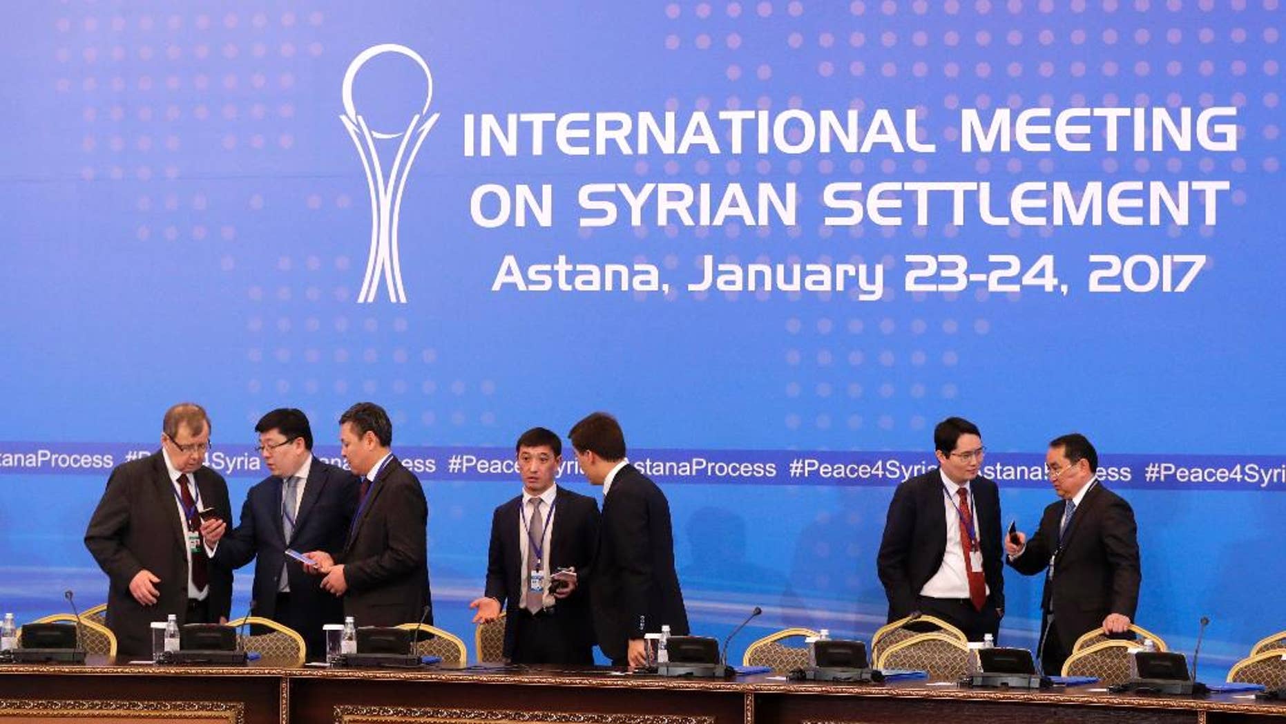 Kazakhstan's officials prepare working space for delegations at a hotel lobby where Russia, Iran and Turkey will hold talks on Syrian peace, in Astana, Kazakhstan, Monday, Jan. 23, 2017. The talks are the latest attempt to forge a political settlement to end a war that has by most estimates killed more than 400,000 people since March 2011 and displaced more than half the country's population. (AP Photo/Sergei Grits)
