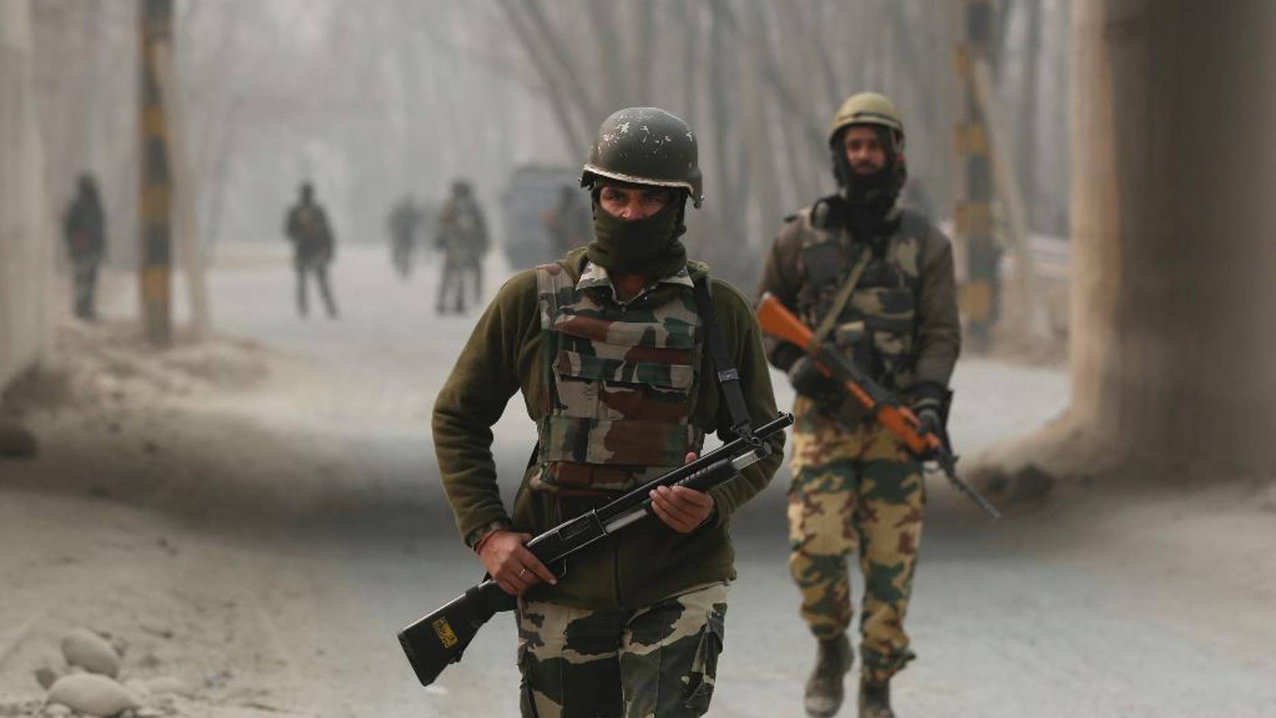 Indian soldiers block a road near the site of a gun battle at Arwani, 55 kilometers (34 miles) south of Srinagar, Indian-controlled Kashmir, Thursday, Dec. 8, 2016. Dozens of civilians in Indian-controlled Kashmir were injured on Thursday as anti-India clashes erupted in the disputed region following a gun battle between rebels and government forces, officials and witnesses said. (AP Photo/Mukhtar Khan)