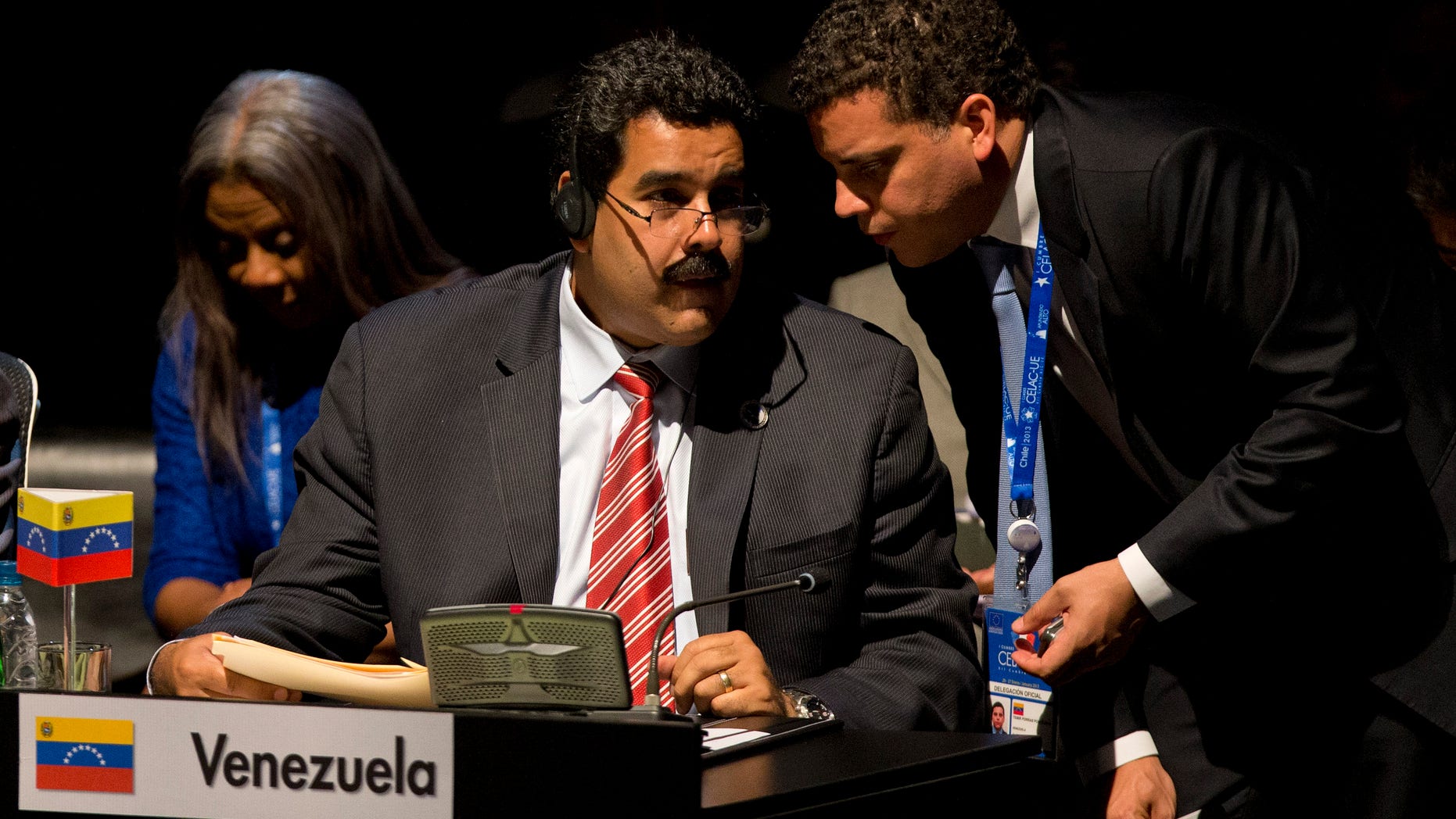 Venezuela's Vice President Nicolas Maduro, left, speaks and a member of his delegation speak during the closing ceremony of the CELAC-EU summit in Santiago, Chile, Sunday, Jan. 27, 2013. A 60-nation summit wrapped up in Chile on Sunday with leaders from the European Union, Latin America and the Caribbean renewing calls for giving investors "legal certainty" and dropping barriers to trade between economies that together represent a billion people and $280 billion in commerce. (AP Photo/Victor R. Caivano)