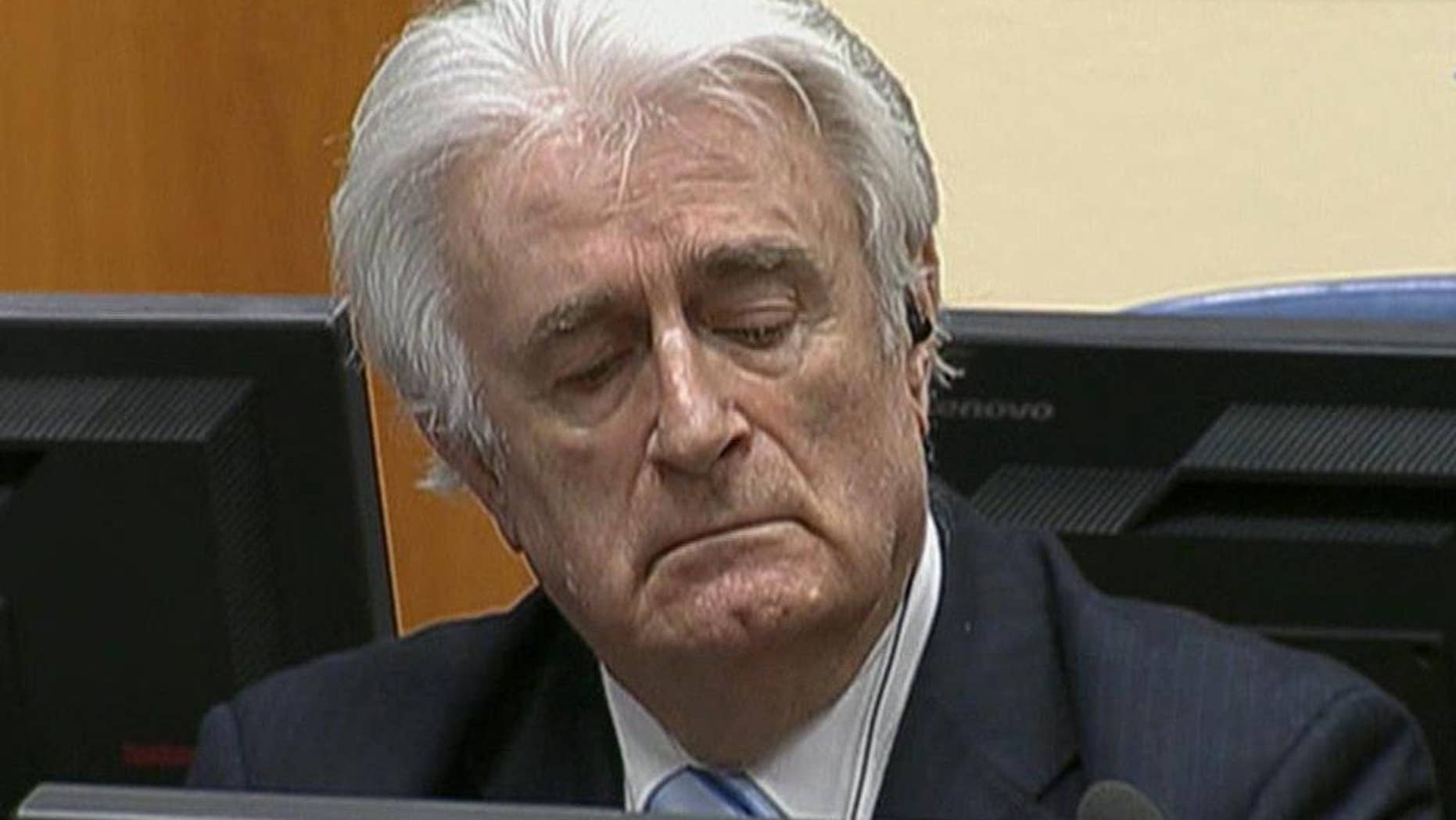 In this image taken from video Bosnian Serb wartime leader Radovan Karadzic listens to the his sentence at the International Criminal Tribunal for Former Yugoslavia (ICTY) in The Hague, The Netherlands Thursday March 24, 2016. Karadzic was convicted of genocide and nine other charges Thursday at a U.N. court, and sentenced to 40 years in prison. (ICTY, Pool via AP)