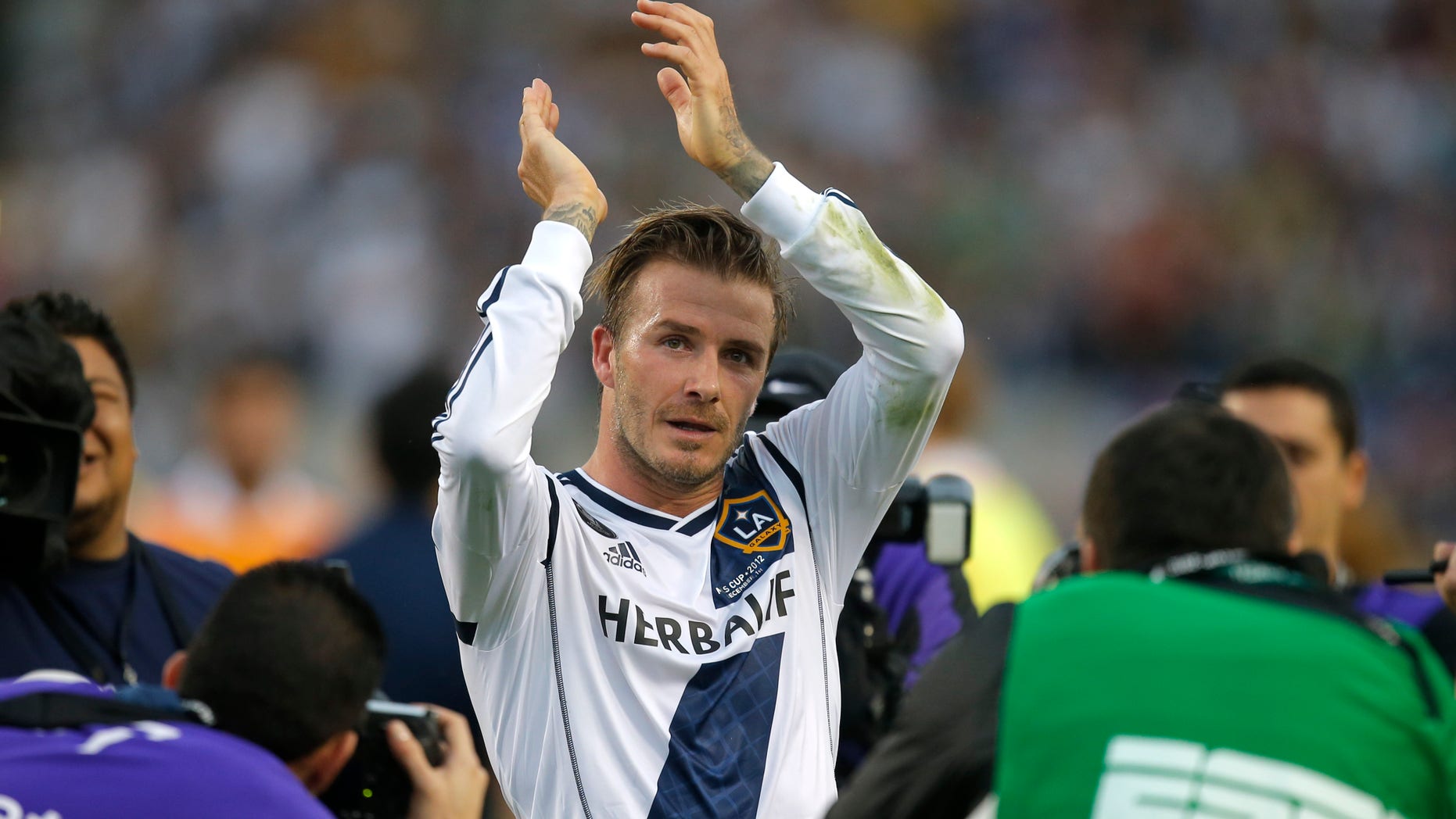 FILE - In this Saturday, Dec. 1, 2012 file photo Los Angeles Galaxy's David Beckham, of England, acknowledges the fans as he leaves the field after the team's 3-1 win in the MLS Cup championship soccer match against the Houston Dynamo in Carson, Calif. According to reports Thursday Jan. 31, 2013, David Beckham is to join Paris Saint-Germain. (AP Photo/Jae C. Hong, File)