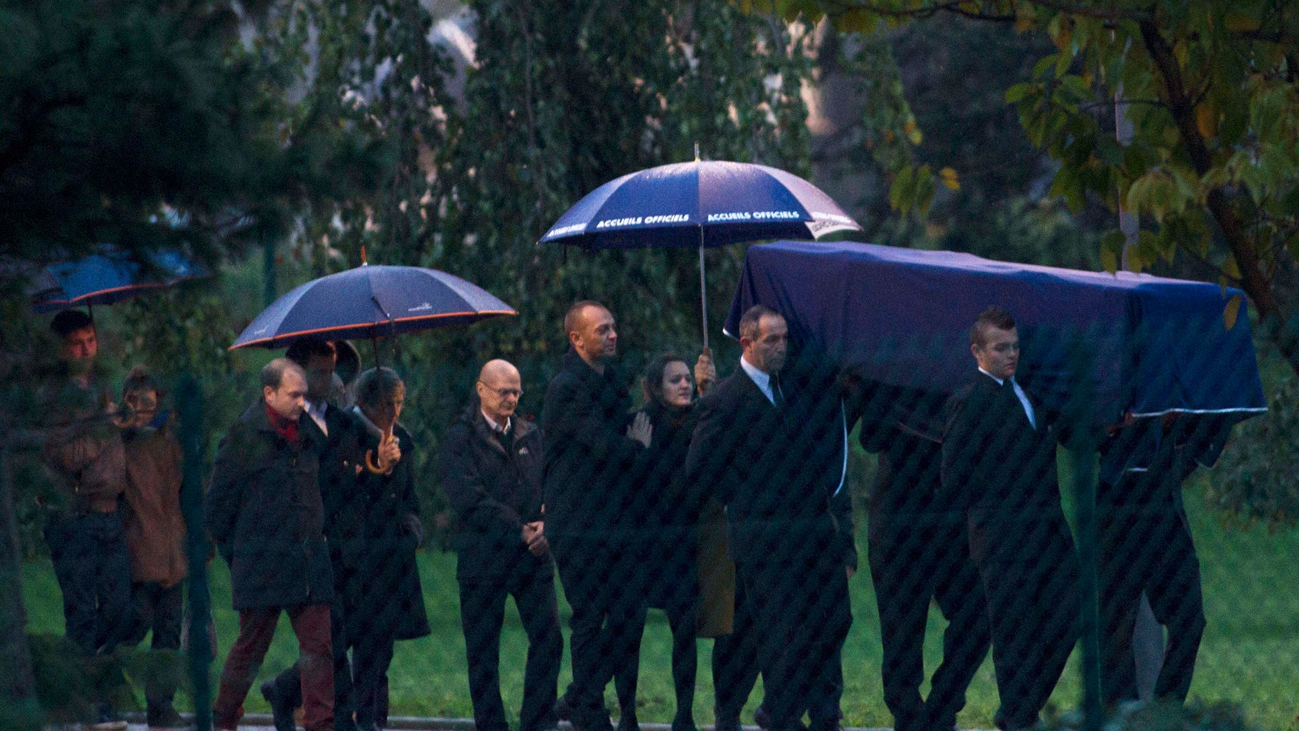 A coffin bearing the body of one of the two French radio journalists killed in Mali is carried at Roissy Charles de Gaulle Airport in Roissy, north of Paris, Tuesday, Nov. 5, 2013. The slayings of Ghislaine Dupont, 57, a senior correspondent, and Claude Verlon, 55, a production technician, stunned France and were an unheard of assault on Western journalists in Mali, where a French-led military operation this year aimed to clear out Islamic extremists who had taken over the vast north. (AP Photo/Thibault Camus)