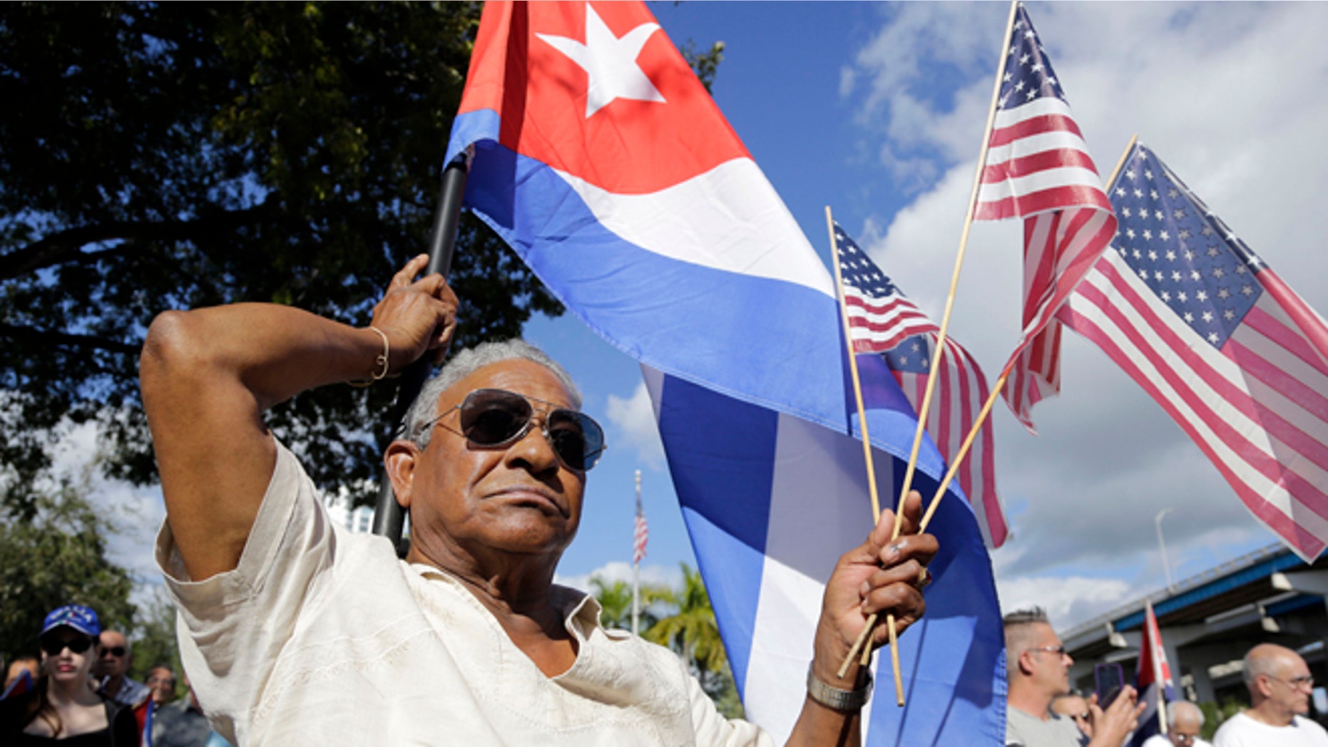 Evilio Ordonez holds Cuban and American flags during a protest against President Barack Obama's plan to normalize relations with Cuba, Saturday, Dec, 20, 2014, in the Little Havana neighborhood of Miami. Florida newspaper editors voted President Barack Obamas mid-December move to normalize relations with Cuba as one of the top stories of the year. (AP Photo/Lynne Sladky)