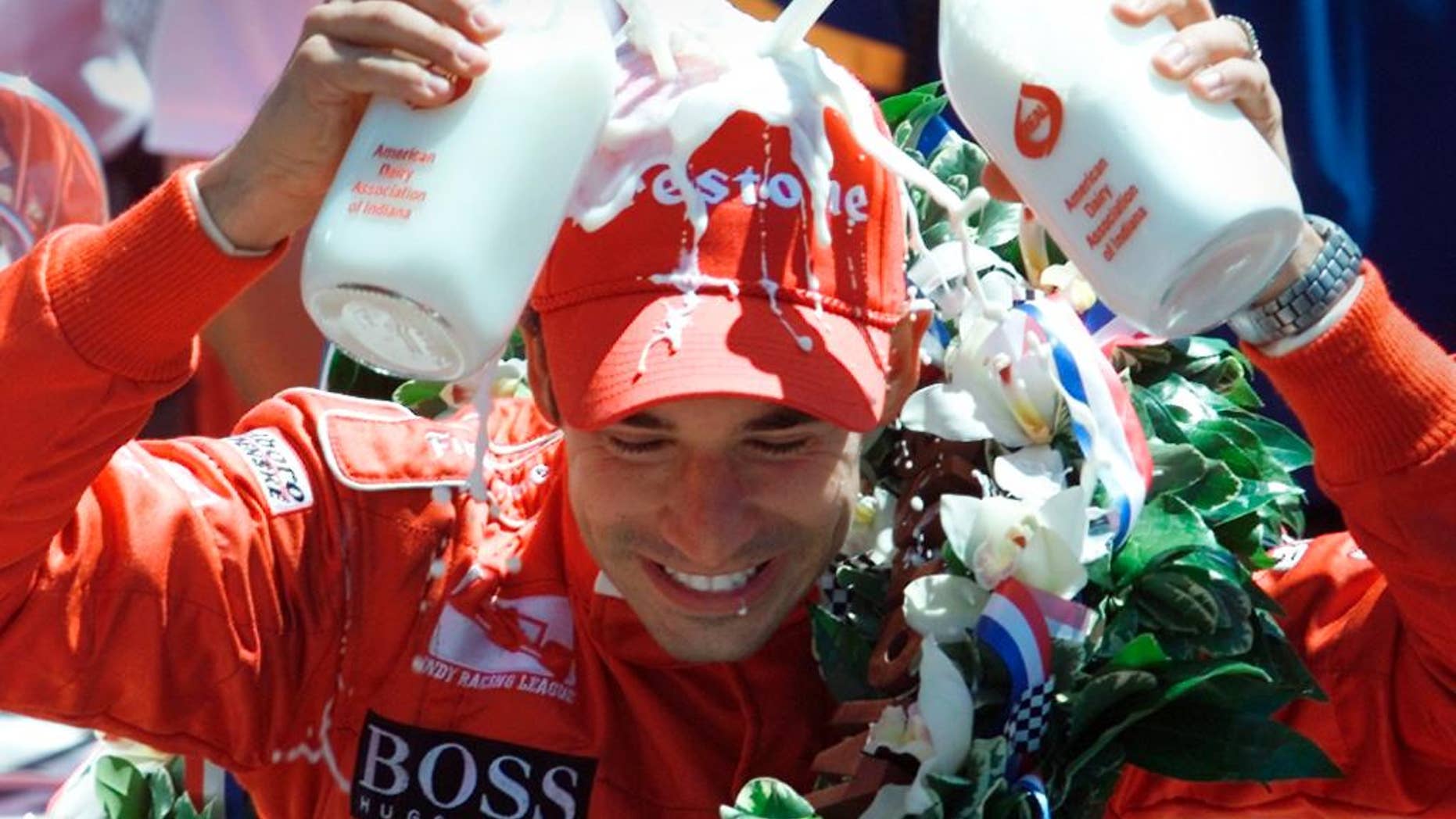 FILE - In this May 26, 2002, file photo, Indianapolis 500 champion Helio Castroneves of Brazil pours two bottles of milk onto his head after winning his second consecutive Indianapolis 500 auto race, in Indianapolis. (AP Photo/Michael Conroy, File)