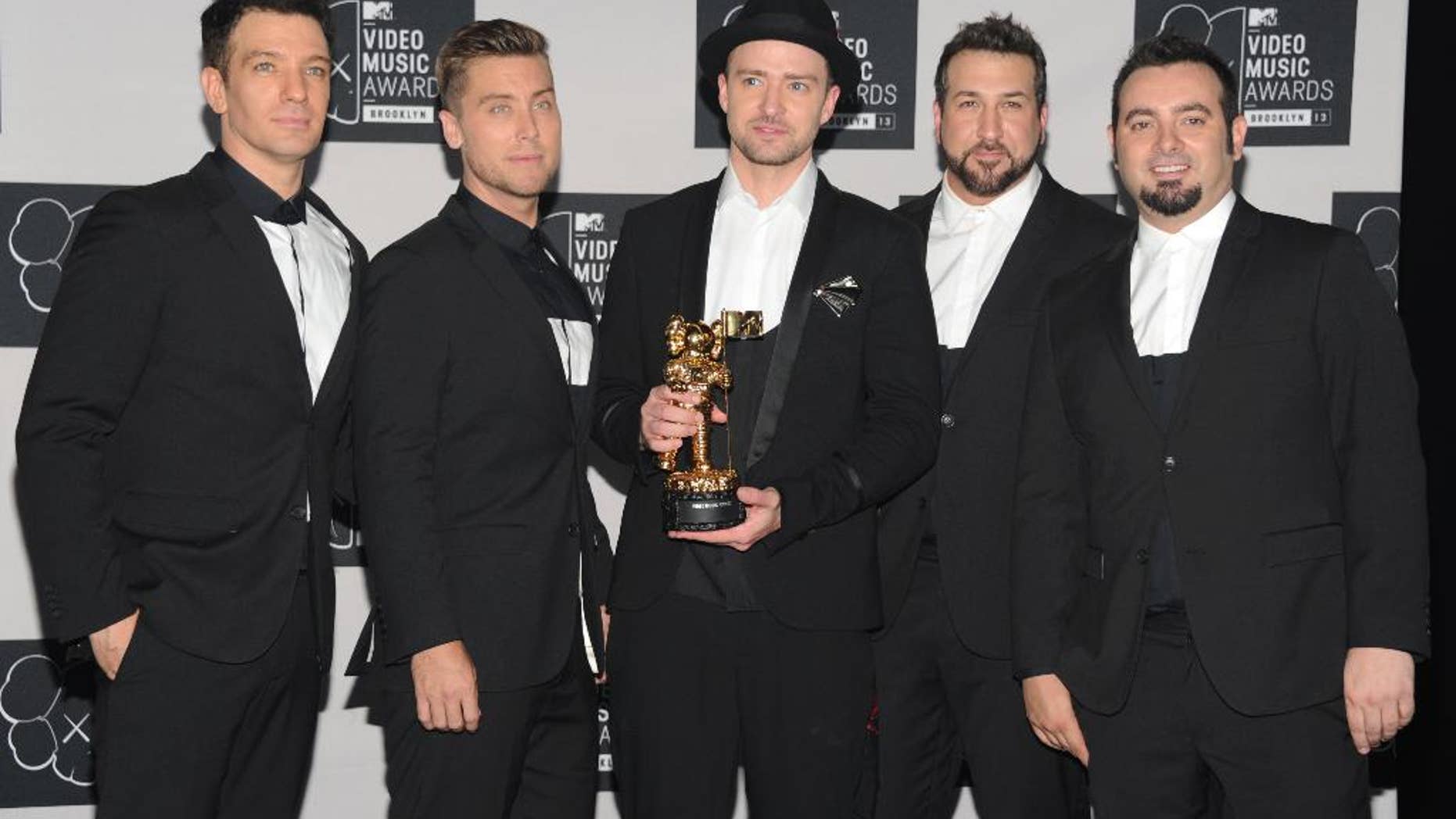 FILE - In this Aug. 25, 2013, file photo, Justin Timberlake, center, winner of the video vanguard award poses backstage with, from left, JC Chasez, Lance Bass, Joey Fatone and Chris Kirkpatrick of NSYNC at the MTV Video Music Awards at the Barclays Center in New York. Timberland and the band's Twitter account posted a picture of the group celebrating Chasez's 40th birthday party on Aug. 9, 2016. (Photo by Evan Agostini/Invision/AP, File)