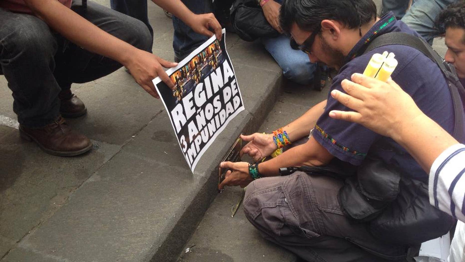 In this April 28, 2015 photo, Mexican photojournalist Ruben Espinosa places a plaque to rename a plaza after slain journalist Regina Martinez in the city of Xalapa, in Mexico's Gulf state of Veracruz. Three years ago Martinez was killed and now on August 1, Espinosa himself was tortured and killed along with four other people inside an apartment building in Mexico City, the city where he had sought refuge after being threatened in the state of Veracruz. (AP Photo/Katherine Corcoran)
