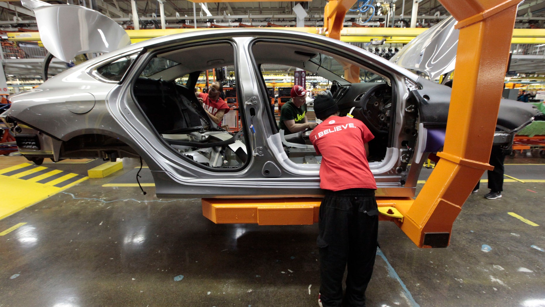FILE - In this March 14, 2014 photo, assembly line workers build a 2015 Chrysler 200 automobile at the Sterling Heights Assembly Plant in Sterling Heights, Mich. Lured by low wages and tax-saving free trade agreements, auto companies from the U.S. and overseas are accelerating plans to build new factories and add jobs in Mexico. The moves, part of a decade-long trend, are luring investments and work that could have gone to the U.S. and Canada, according to experts. But they also are likely to keep car and truck prices in check even as automakers add expensive fuel-saving features to meet U.S. gas mileage requirements. (AP Photo/Paul Sancya)