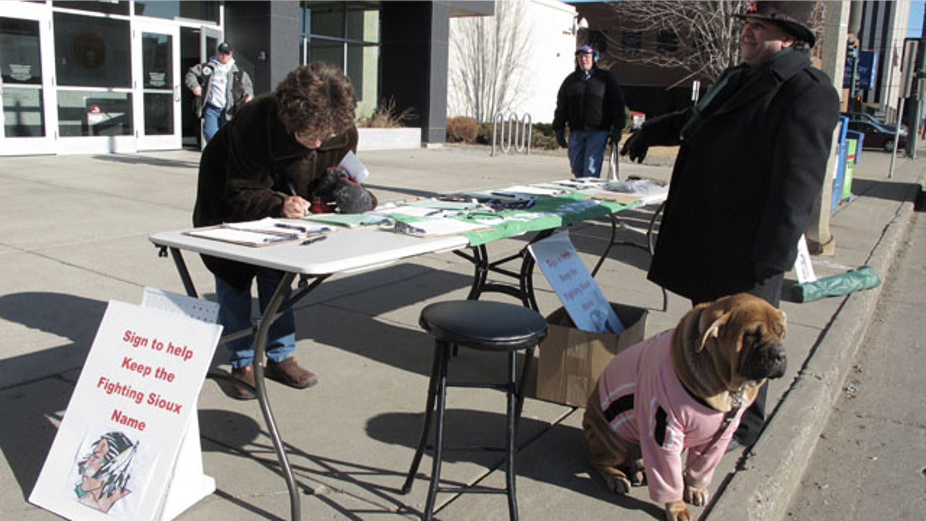 Feb. 7, 2012: Charles Tuttle, a backer of the University of North Dakota's Fighting Sioux nickname, watches as a woman signs petitions supporting the nickname in front of the federal courthouse in Bismarck, N.D.