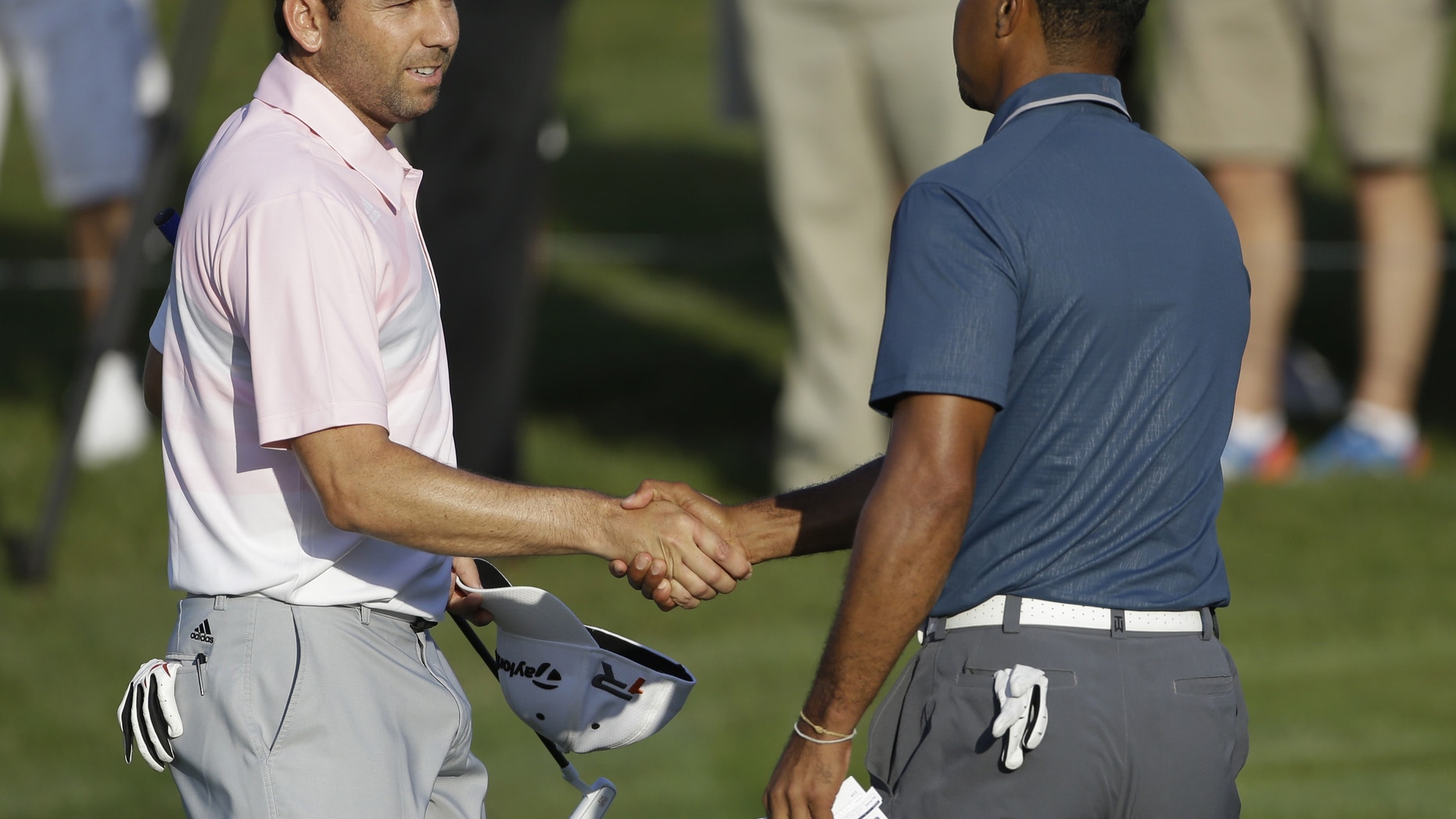 Sergio Garcia, of Spain, left, shakes hands with Tiger Woods at the conclusion of the third round of The Players championship golf tournament at TPC Sawgrass, Sunday, May 12, 2013, in Ponte Vedra Beach, Fla. Play was suspended Saturday due to darkness. (AP Photo/Gerald Herbert)