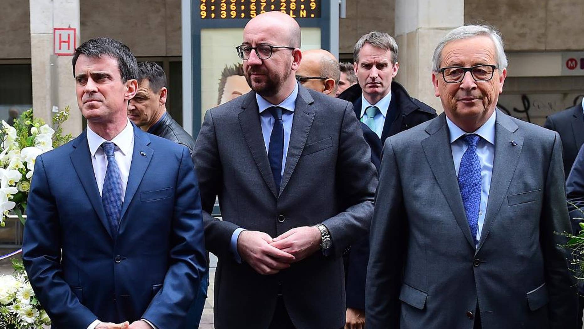 From left, French Prime Minister Manuel Valls, Belgian Prime Minister Charles Michel and European Commission President Jean-Claude Juncker prepare to lay flowers at the Maelbeek metro station in Brussels on Wednesday, March 23, 2016. Belgian authorities were searching Wednesday for a top suspect in the country's deadliest attacks in decades, as the European Union's capital awoke under guard and with limited public transport after scores were killed and injured in bombings on the Brussels airport and a subway station. (Emmanuel Dunand, Pool Photo via AP)
