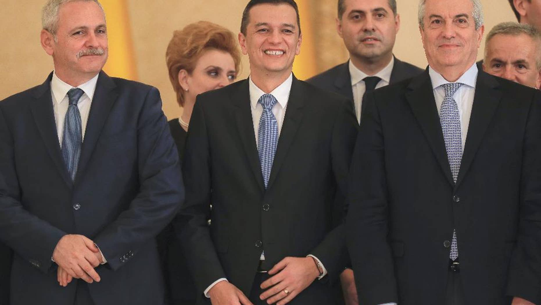 Romanian Prime Minister Sorin Grindeanu, center, smiles while standing between Liviu Dragnea, the leader of the Social Democratic party, left, and Calin Popescu Tariceanu, head of Romania's Senate, after the swearing in ceremony for his cabinet, in Bucharest, Romania, Wednesday, Jan. 4, 2017. Iohannis swore in the new government shortly after it was voted in by parliament, urging it to guarantee an independent justice system and the rule of law, and strengthen its position within the European Union and NATO.(AP Photo/Vadim Ghirda)