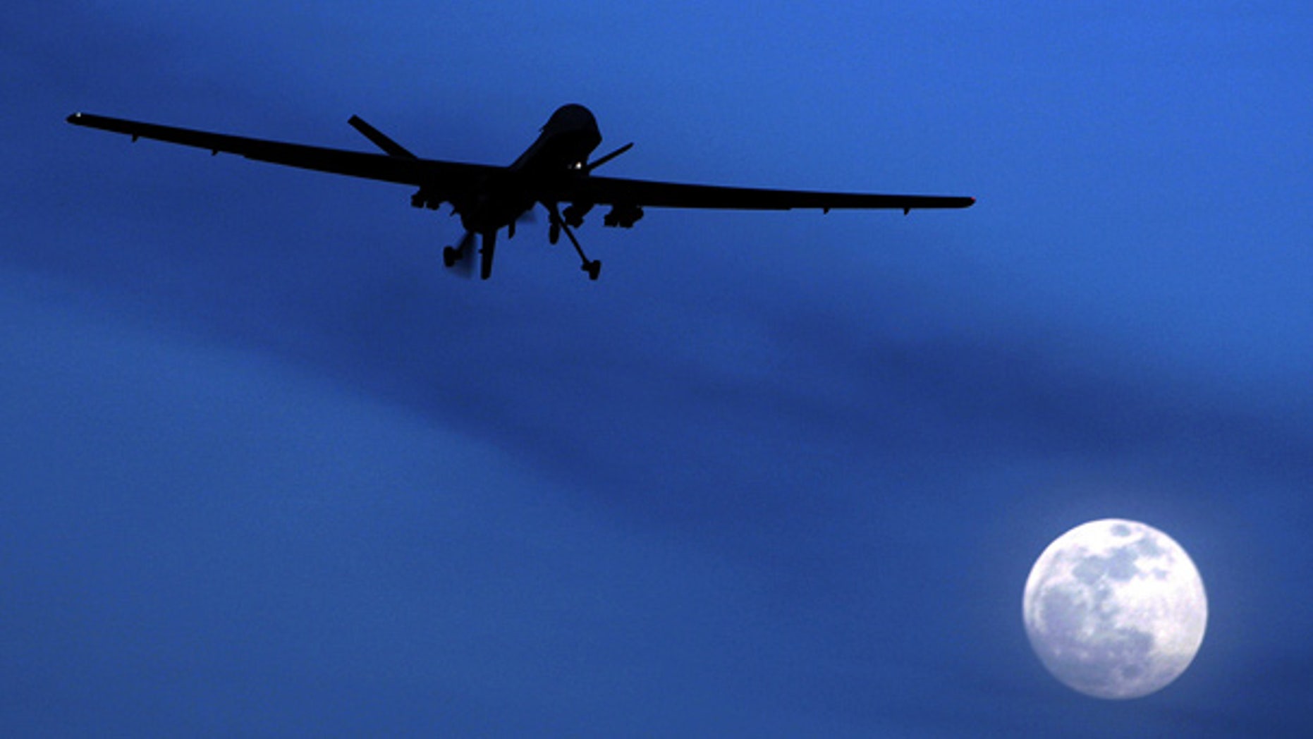 A U.S. Predator drone flies over the moon above Kandahar Air Field, Afghanistan.
