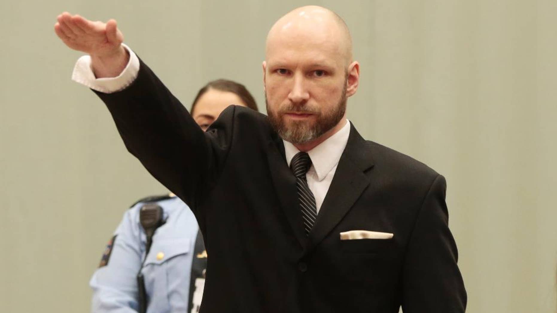 Anders Behring Breivik raises his right hand at the start of his appeal case in Borgarting Court of Appeal at Telemark prison in Skien, Norway, Tuesday, Jan. 10, 2017. Norwegian mass murderer Anders Behring Breivik walked quietly into a courtroom at a high security prison Tuesday, making a neo-Nazi salute, as judges began reviewing a government appeal against a ruling that his solitary confinement was inhumane and violated human rights. (Lise Aaserud/NTB Scanpix via AP)