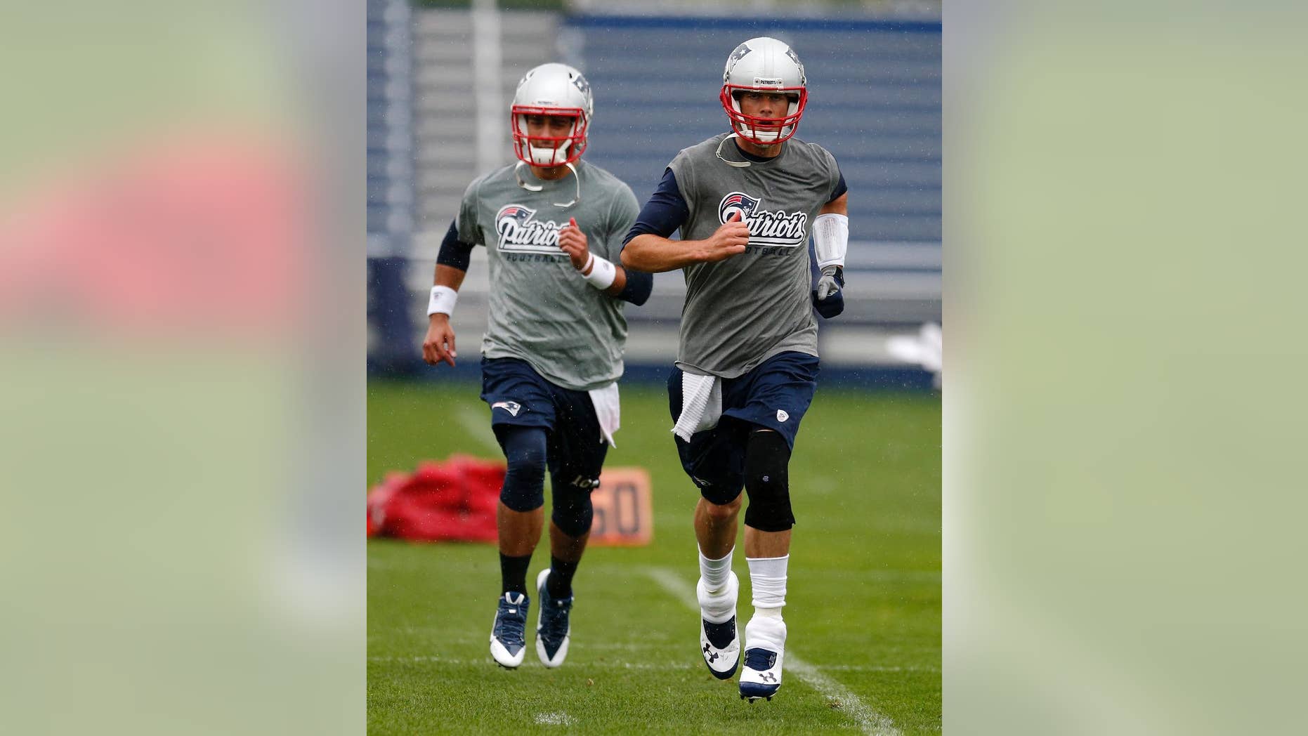 New England Patriots quarterback Tom Brady, right, and quarterback Jimmy Garoppolo work out during an NFL football organized team activity in Foxborough, Mass., Thursday, June 5, 2014. (AP Photo/Michael Dwyer)