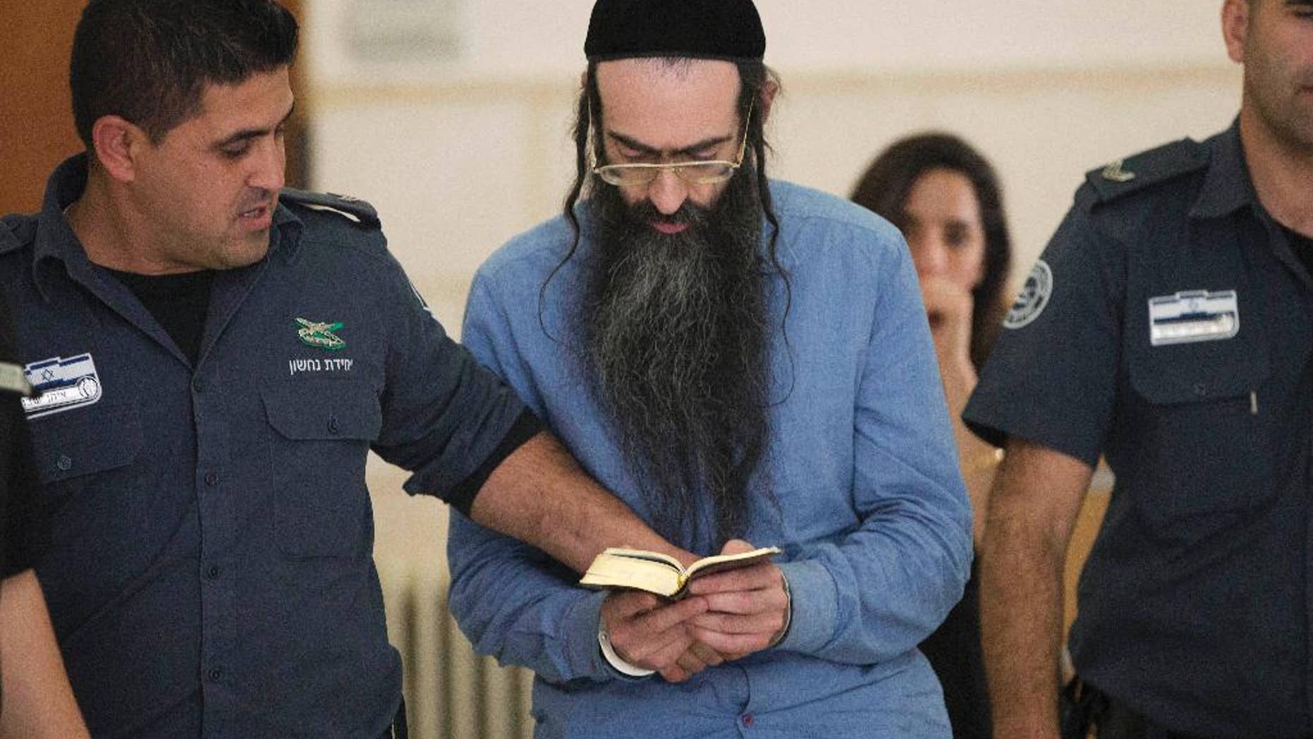 Yishai Schlissel, who fatally stabbed a teenage girl and wounded others at last year Jerusalem's gay pride parade, reads scripture at court in Jerusalem, Tuesday, April 19, 2016. The District Court convicted Schlissel for murder for last year’s deadly attack, along with multiple attempted murder charges for those he wounded. (AP Photo/Oded Balilty)