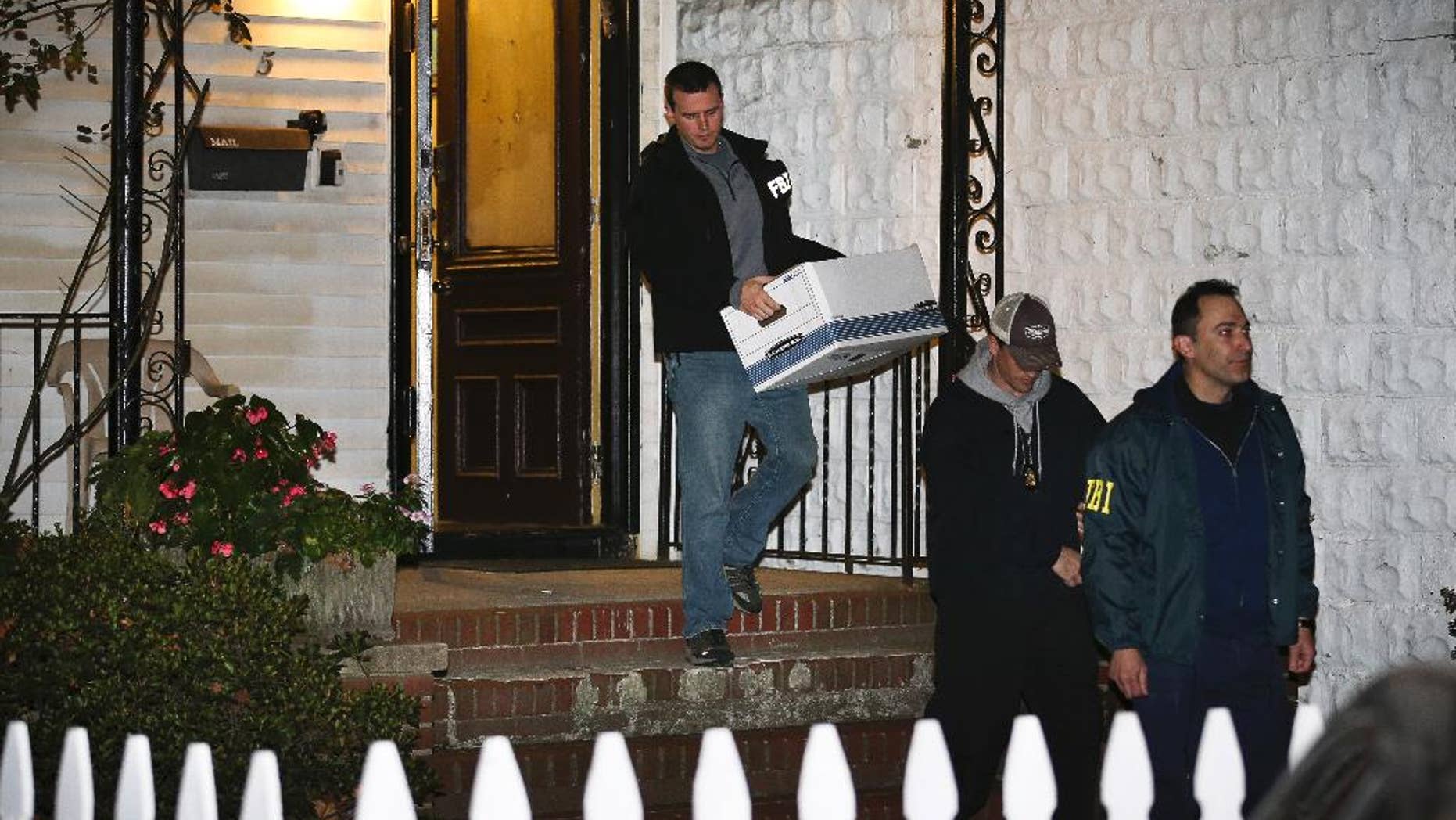 FILE - In a Thursday, Oct. 10, 2013 file photo, FBI agents remove evidence from the Brooklyn residence of Rabbi Mendel Epstein during an investigation, in New York. Several defendants, including Epstein and another rabbi, are accused by the FBI of plotting to kidnap and beat a man to force him to grant a religious divorce. Epstein’s trial starts Tuesday, Feb. 17, 2015, in federal court in New Jersey. Several co-defendants have pleaded guilty and others will join him in court this week. (AP Photo/John Minchillo, File)