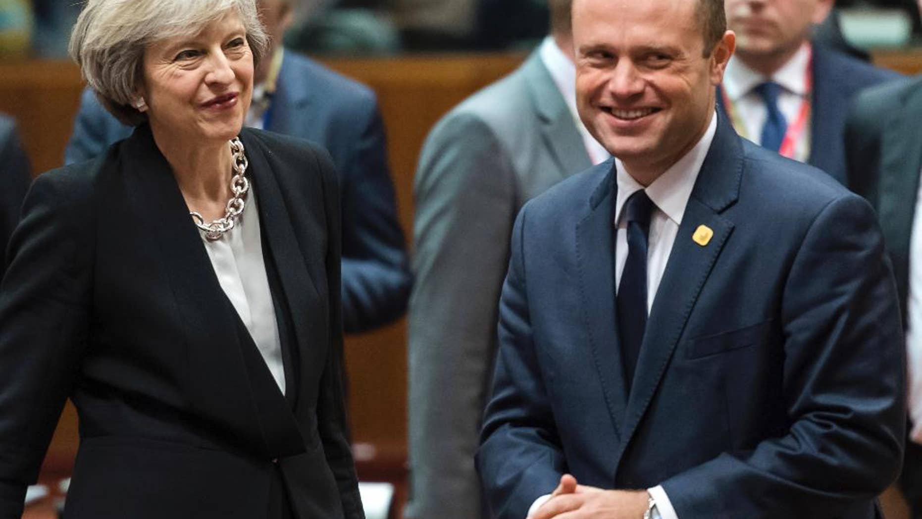 FILE - This is a Thursday, Dec. 15, 2016 file photo of British Prime Minister Theresa May, left, speaks with Malta's Prime Minister Joseph Muscat, during a round table meeting at an EU Summit in Brussels . Muscat the leader of the European Union’s smallest nation warned Britain on Wednesday Jan. 11, 2016 that it can only lose by leaving the EU and that no member state is likely to break ranks and negotiate with London until it has departed. (AP Photo/Geert Vanden Wijngaert, File)