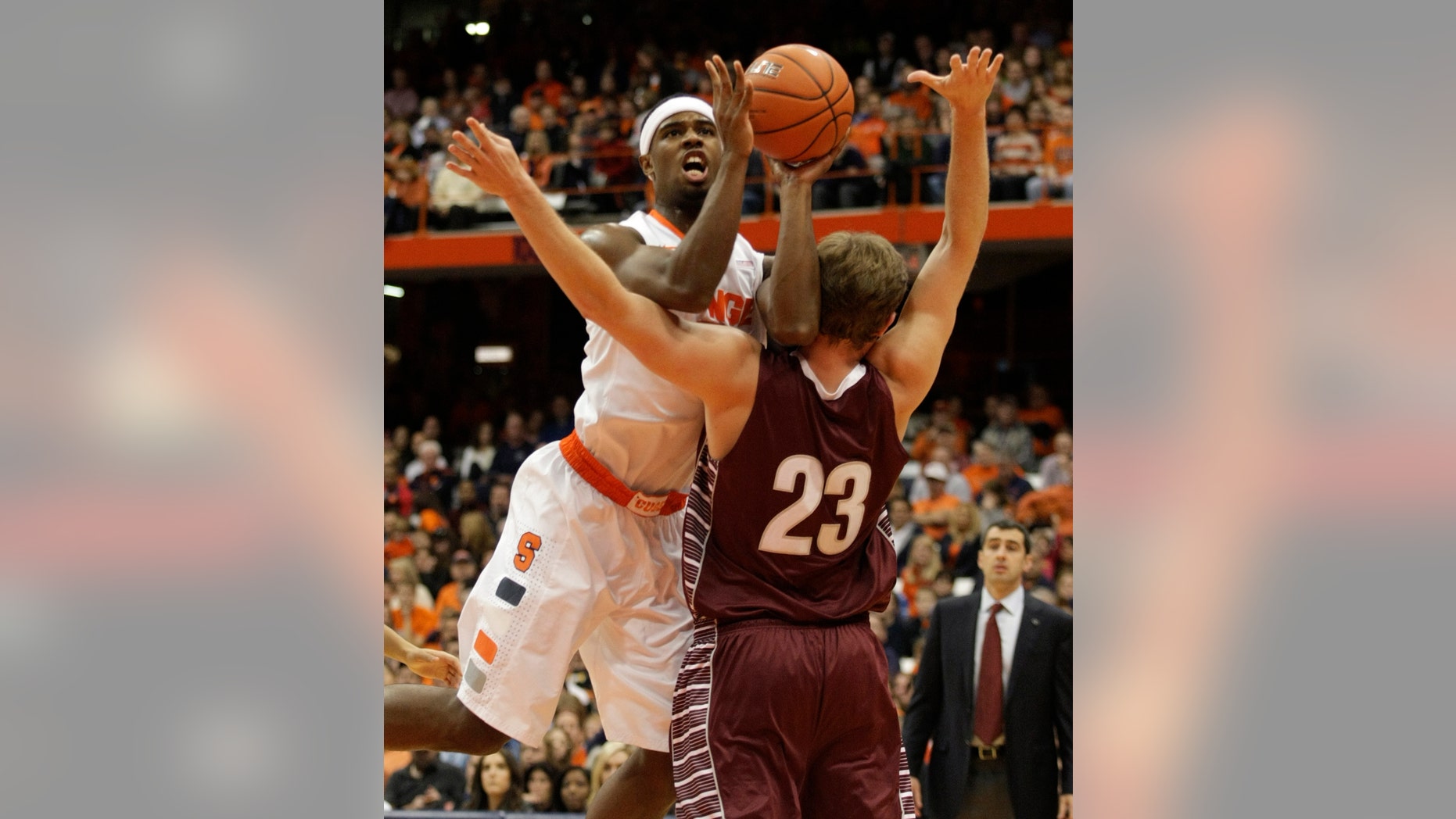 Syracuse’s C.J. Fair, left, hits Colgate’s Clayton Graham as Fair shoots in the first half of an NCAA college basketball game in Syracuse, N.Y., Saturday, Nov. 16, 2013. (AP Photo/Nick Lisi)