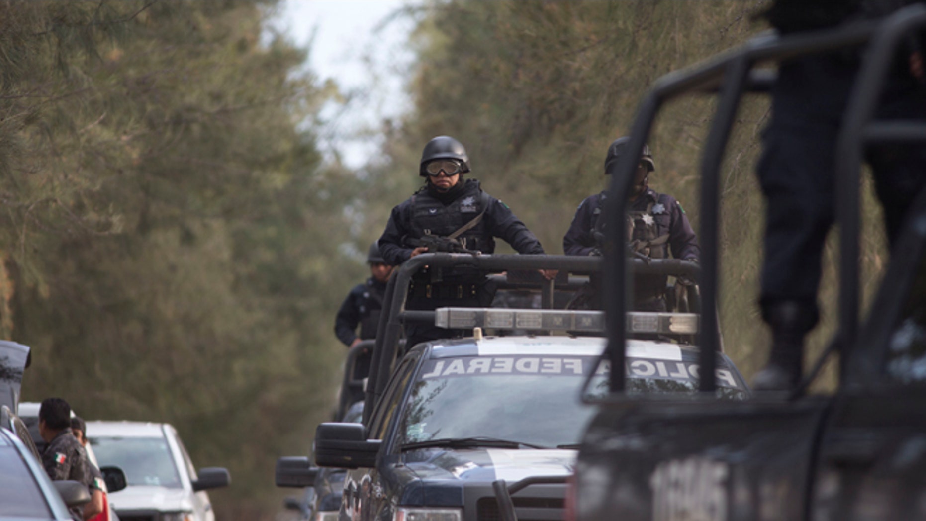 Mexican Federal Police stand guard near the entrance of Rancho del Sol, near Ecuanduero, in western Mexico, Friday, May 22, 2015. At least 43 people died Friday in what authorities described as a fierce, three-hour gunbattle between federal forces and suspected drug gang gunmen at the ranch. (AP Photo/Eduardo Verdugo)
