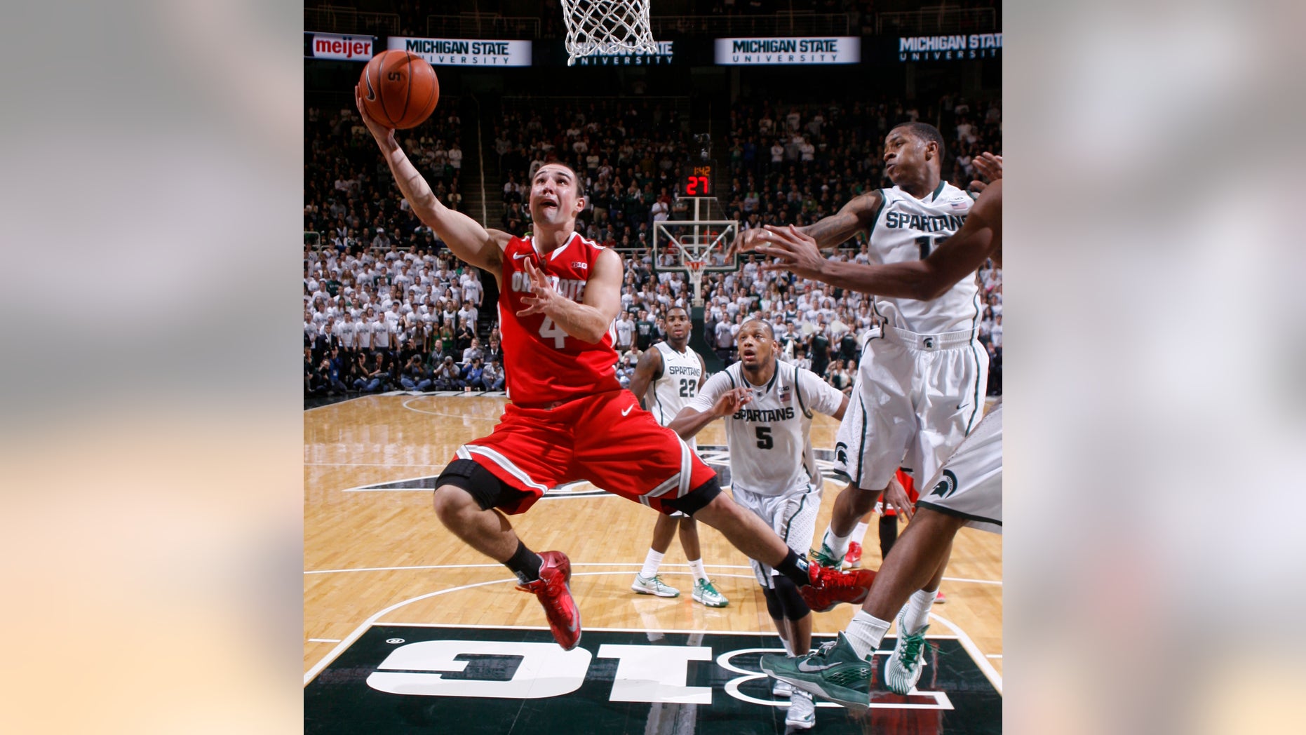 Ohio State's Aaron Craft (4) lays the ball up against Michigan State's Keith Appling, right, during overtime of an NCAA college basketball game, Tuesday, Jan. 7, 2014, in East Lansing, Mich. Michigan State won 72-68 in overtime. (AP Photo/Al Goldis)