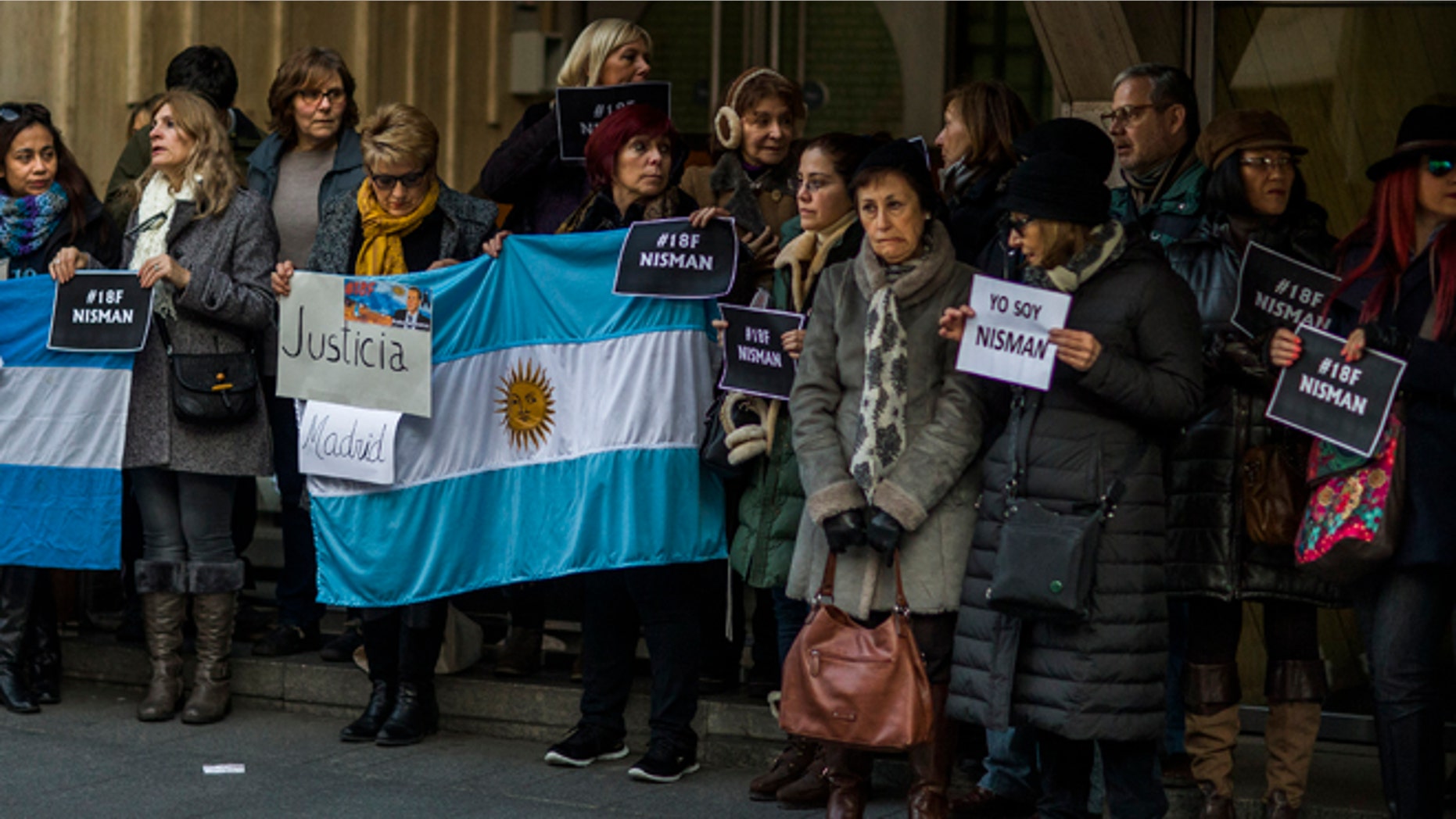 People hold signs reading in Spanish "Justice" and "I am Nisman" as they gather for justice and against impunity in the case of the mysterious death of late prosecutor Alberto Nisman outside the Argentinean Embassy in Madrid, Spain, Wednesday, Feb. 18, 2015. Nisman was scheduled to appear before Congress the day after he was found dead in his apartment on Jan. 18, to detail his allegations that President Cristina Fernandez had conspired to protect some of the Iranian suspects in the 1994 bombing of a Jewish center. (AP Photo/Andres Kudacki)