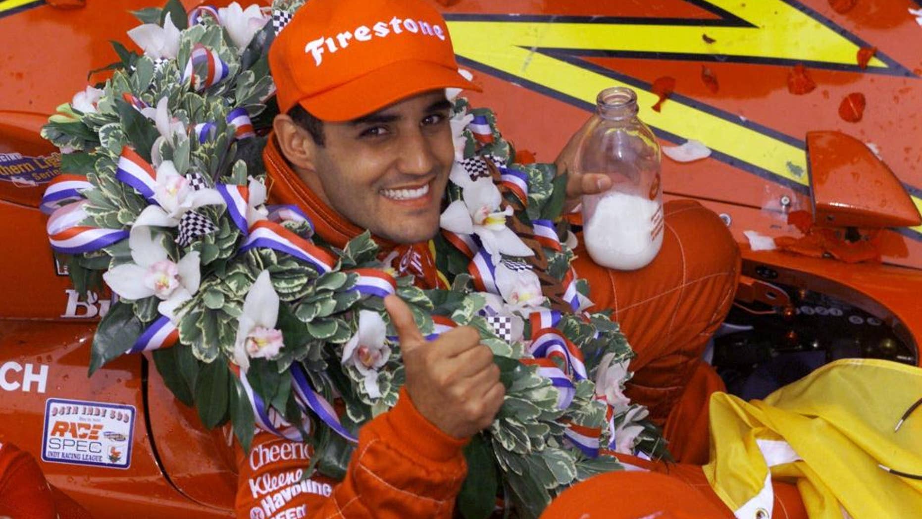 FILE - In this May 28, 2000 file photo, Juan Pablo Montoya of Colombia gives a thumbs-up while holding a bottle of milk after winning the 84th edition of the Indianapolis 500 auto race at Indianapolis Motor Speedway. (AP Photo/Michael Conroy, File)