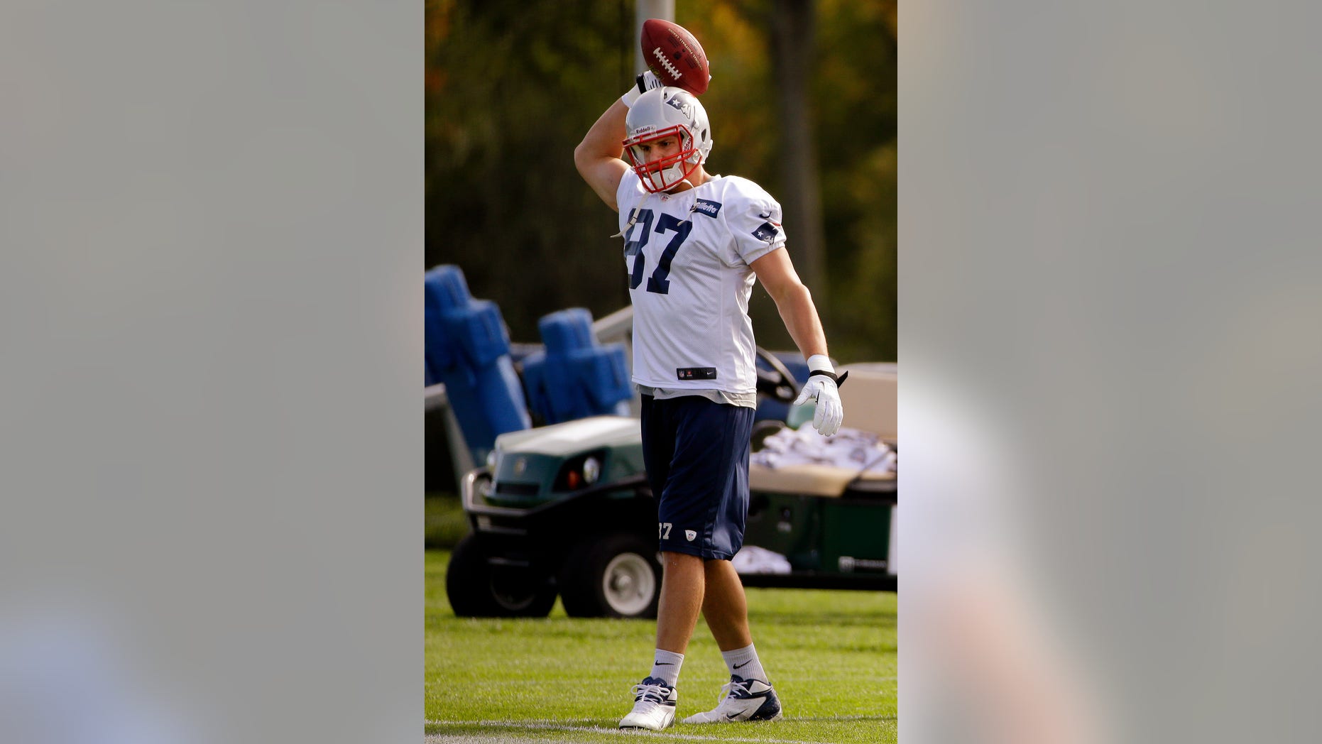 New England Patriots tight end Rob Gronkowski throws a football during a stretching and drills session before NFL football practice begins at the team's facility in Foxborough, Mass., Wednesday, Oct. 9, 2013. The Patriots host the New Orleans Saints on Sunday. (AP Photo/Stephan Savoia)