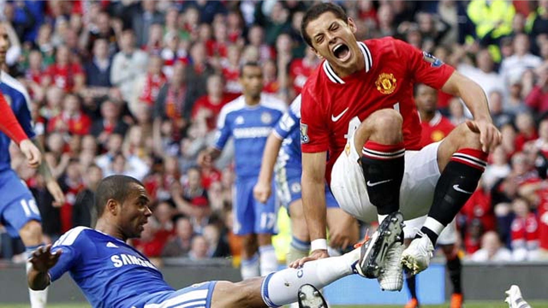 In this photo taken Sunday Sept. 18, 2011, Manchester United's Javier Hernandez reacts during a tough challenge from Chelsea's Ashley Cole, left, during the English Premier League soccer match at Old Trafford, Manchester. Hernandez limped off in the second half after the challenge by Cole. (AP Photo/Peter Byrne, PA) UNITED KINGDOM OUT