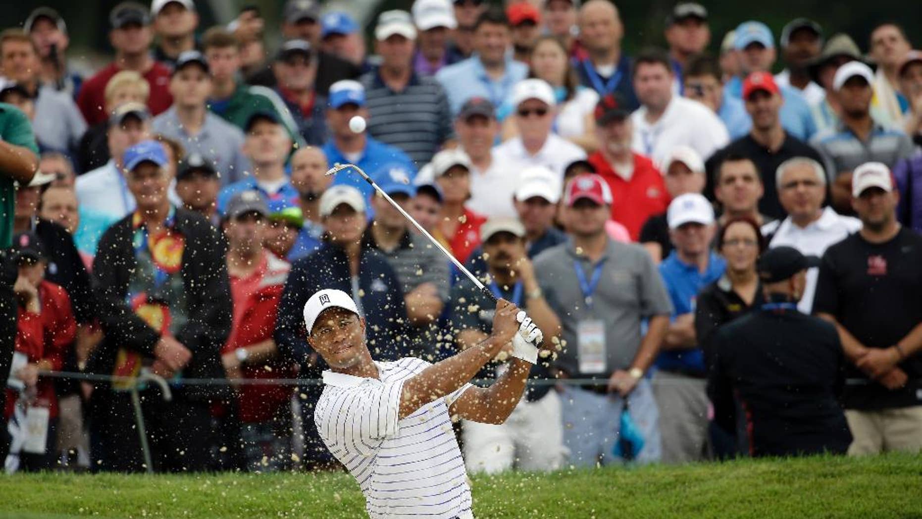 Tiger Woods hits out of the bunker on the first hole during the second round of the PGA Championship golf tournament at Valhalla Golf Club on Friday, Aug. 8, 2014, in Louisville, Ky. (AP Photo/Jeff Roberson)