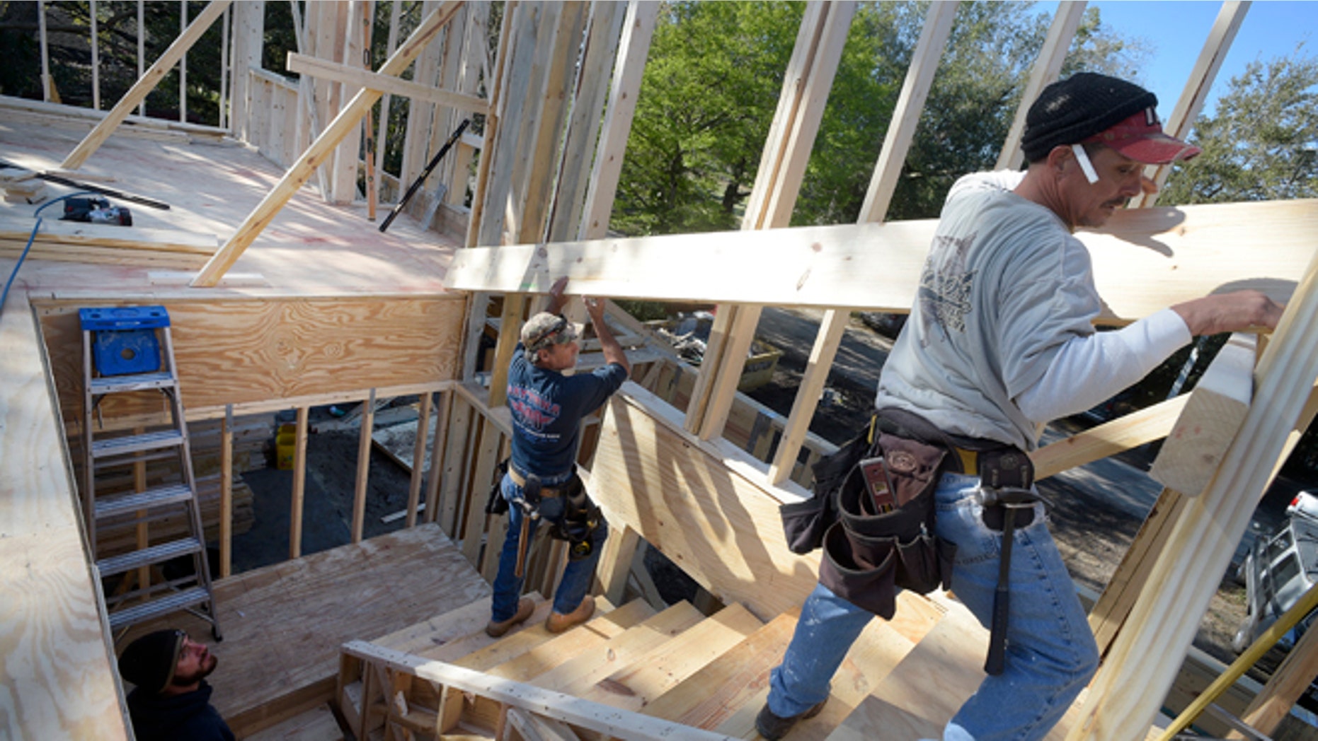 In this Feb. 13, 2015 photo, construction workers James Gibson, left, David Rager, center, and Shawn White frame the second floor of a two-story custom home being built in Orlando, Fla. As construction jobs return in some regions, competition for skilled labor is heating up.(AP Photo/Phelan M. Ebenhack)